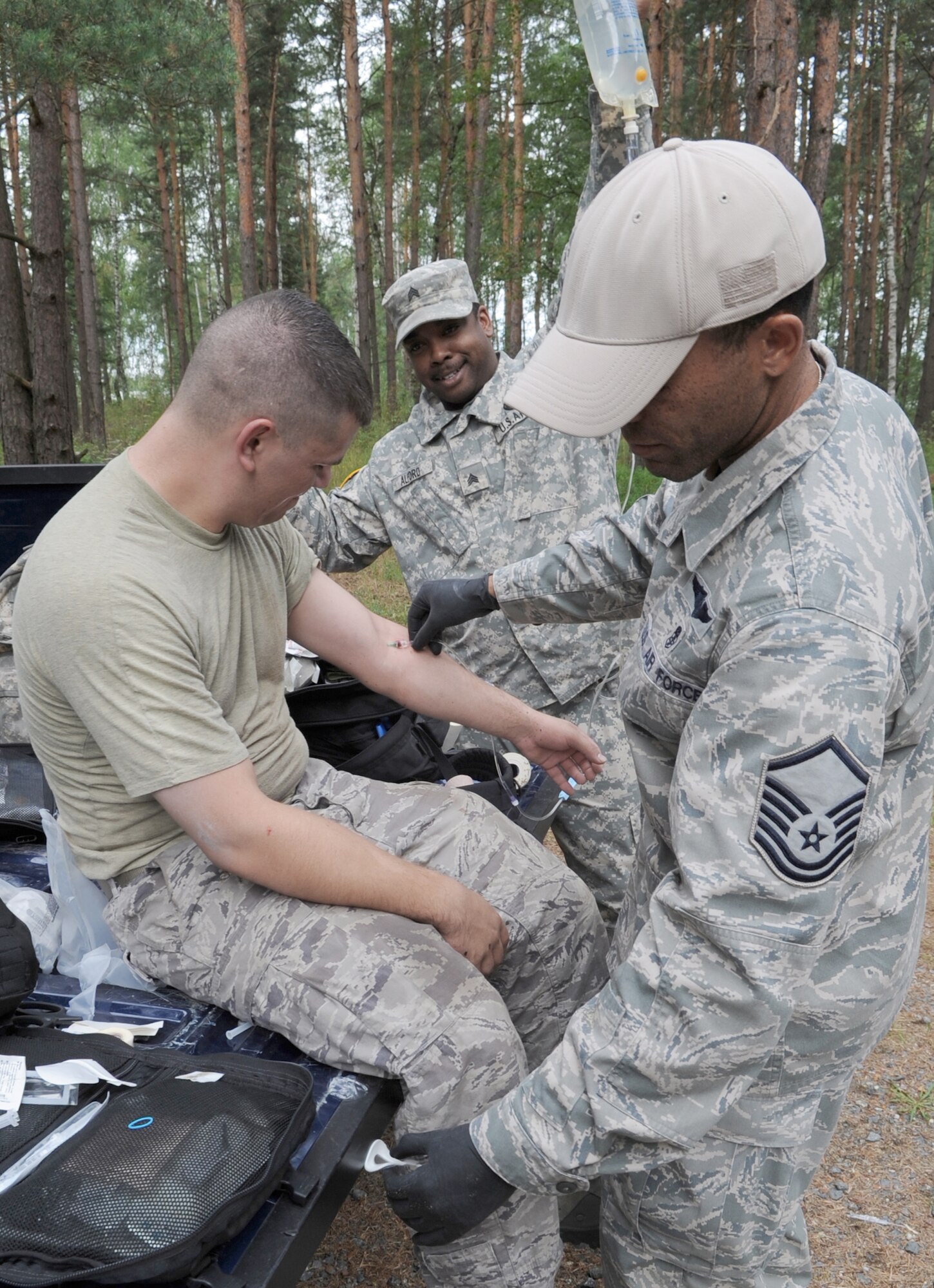 Master Sgt. Ronnie Wright and Army Sgt. Derrick Alford provide medical care to Senior Airman Joshua Romero after completing an obstacle course during Exercise Allied Strike 10 July 23, 2010, Grafenwoehr, Germany. Sergeant Wright is a435th Security Forces Squadron medic, Sergeant Alford is a Headquarters Company combat medic and Airman Romero is assigned to the 1st Air Support Operations Squadron radio maintenance flight. (U.S. Air Force photo/Senior Airman Caleb Pierce) 