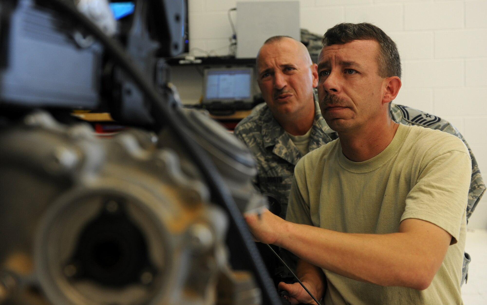 MOODY AIR FORCE BASE, Ga. -- Senior Master Sgt. David Smith, 23rd Component Maintenance Squadron propulsion flight chief, observes Tech. Sgt. Charles Carpentier, 23rd CMS combat search and rescue propulsion section chief,  while he examines the inside of a TF-34 engine here July 22. Sergeants Smith and Carpentier are working together to train all aerospace propulsion technicians to work on any of the three aircraft engines at Moody. (U.S. Air Force photo by Airman 1st Class Benjamin Wiseman/RELEASED)