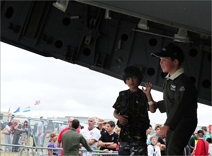 FARNBOROUGH, United Kingdom -- A small child waves as his friend poses for a photograph in the back of a C-17 Globemaster at the 2010 Farnborough International Air Show July 25.  The C-17 and crew came from Travis Air Force Base Calif., and was on static display throughout the duration of the event July 19-25. (U.S. Air Force photo by Staff Sgt. Heather M. Norris)
