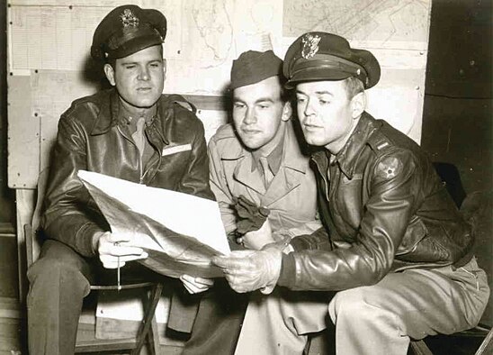 Staff Sgt. Cutler (center) reviewing an aerial map before a mission with fellow aircrew members. (U.S. Air Force Photo by unknown/circa 1945)