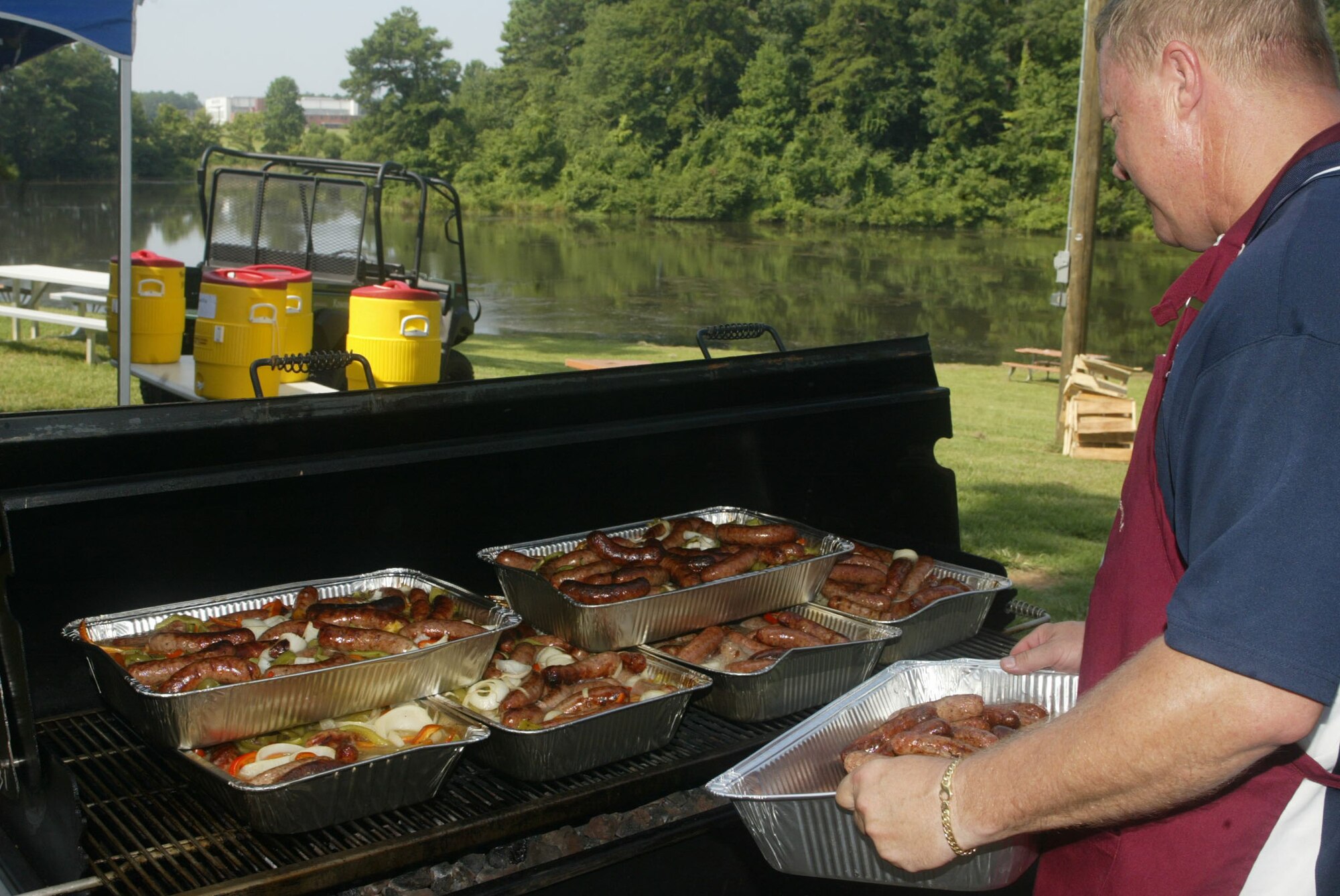 The annual Corn N’ Sausage Roast took place at the Large Base Lake Pavilion here July 21. This year, Chief Master Sgt. Lester C. Davy of the 22nd Air Force along with a team of volunteers  prepared bratwurst and roasted corn for personnel. The annual event also featured a car and motorcycle show. (U.S. Air Force Photo/Don Peek)