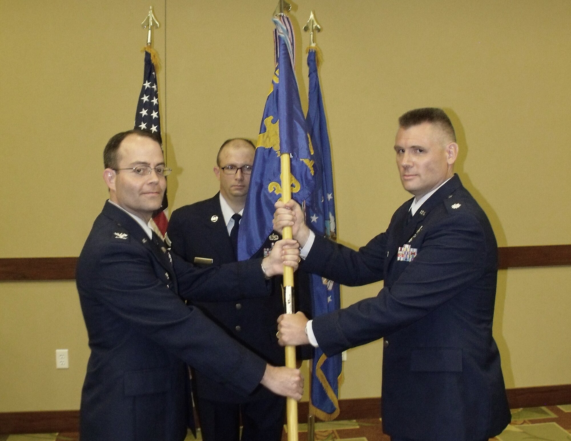 Lt. Col. Brian Denman, incoming 39th Information Operations Squadron commander, receives the 39 IOS guidon from Col. Michael Convertino, 318th Information Operations Group commander, during a change of command ceremony July 20.   Lt. Col. Dean Clothier relinquished command after leading the Air Force’s information operations and cyber formal training unit for two years. (US Air Force photo)