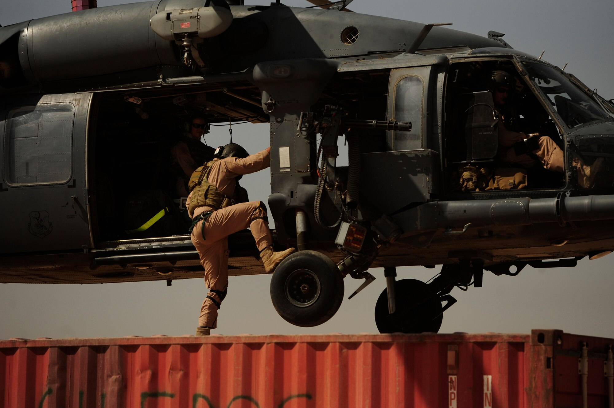 U.S. Air Force Staff Sgt. Aaron Walton, an HH-60G PaveHawk flight engineer assigned to the 64th Expeditionary Rescue Squadron, climbs into the helicopter before takeoff during a flying mission at Joint Base Balad, Iraq, July 12, 2010. (U.S. Air Force photo by Staff Sgt. Andy M. Kin / Released)