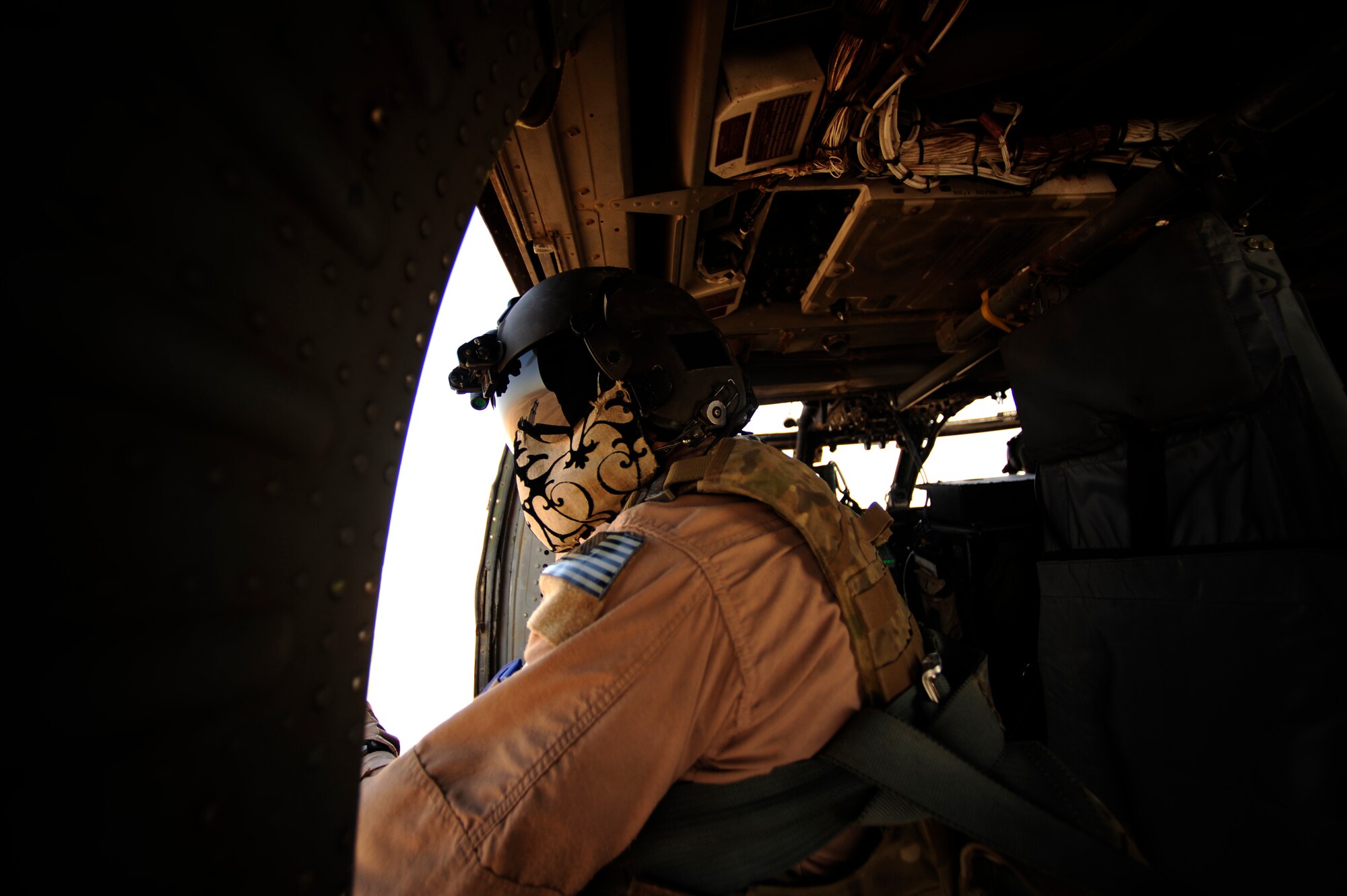 U.S. Air Force Staff Sgt. Andrew Pena, an HH-60G PaveHawk aerial gunner assigned to the 64th Expeditionary Rescue Squadron, scans his sector as a gunner during a flying mission at Joint Base Balad, Iraq, July 12, 2010. (U.S. Air Force photo by Staff Sgt. Andy M. Kin / Released)