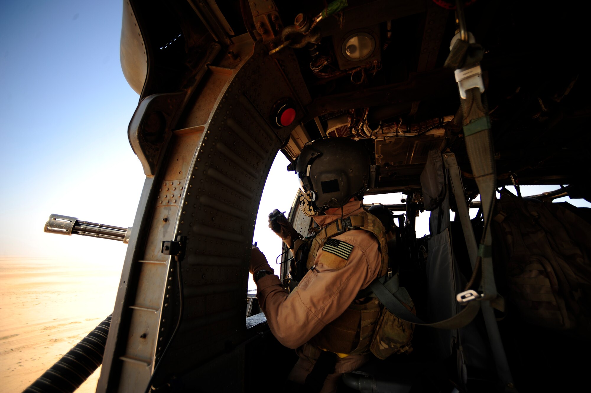 U.S. Air Force Staff Sgt. Andrew Pena, an HH-60G PaveHawk aerial gunner assigned to the 64th Expeditionary Rescue Squadron, scans his sector as a gunner during a flying mission at Joint Base Balad, Iraq, July 12, 2010. (U.S. Air Force photo by Staff Sgt. Andy M. Kin / Released)