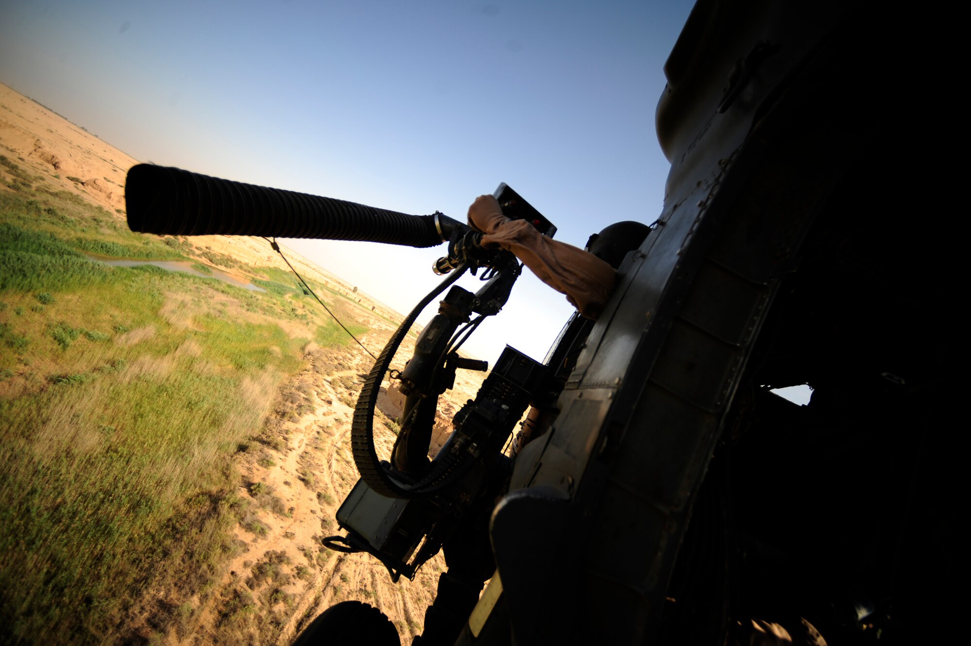 U.S. Air Force Staff Sgt. Andrew Pena, an HH-60G PaveHawk aerial gunner assigned to the 64th Expeditionary Rescue Squadron, scans his sector as a gunner during a flying mission at Joint Base Balad, Iraq, July 12, 2010. (U.S. Air Force photo by Staff Sgt. Andy M. Kin / Released)