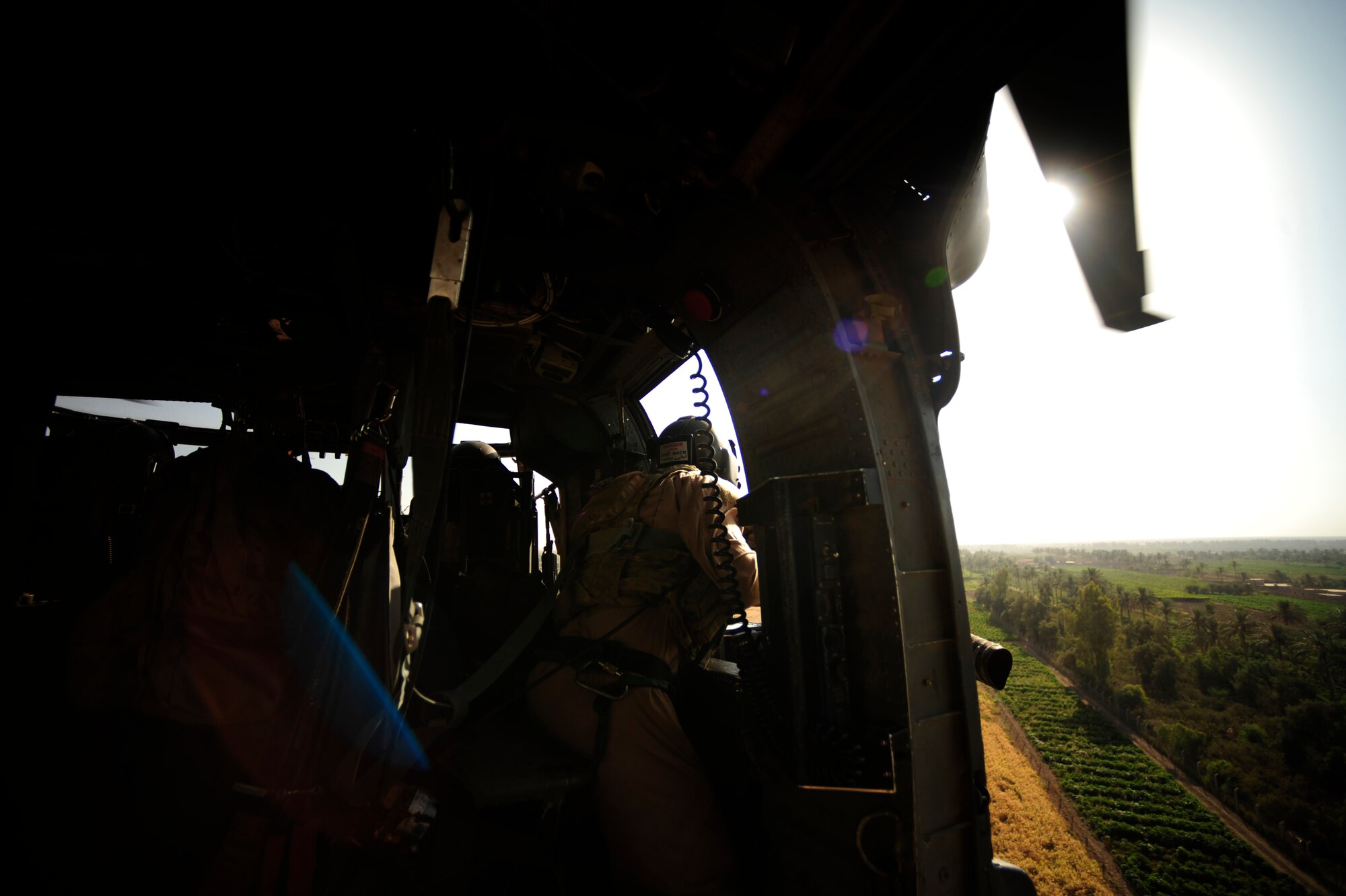 U.S. Air Force Staff Sgt. Aaron Walton, an HH-60G PaveHawk flight engineer assigned to the 64th Expeditionary Rescue Squadron, scans his sector as an aerial gunner during a flying mission at Joint Base Balad, Iraq, July 12, 2010. (U.S. Air Force photo by Staff Sgt. Andy M. Kin / Released)