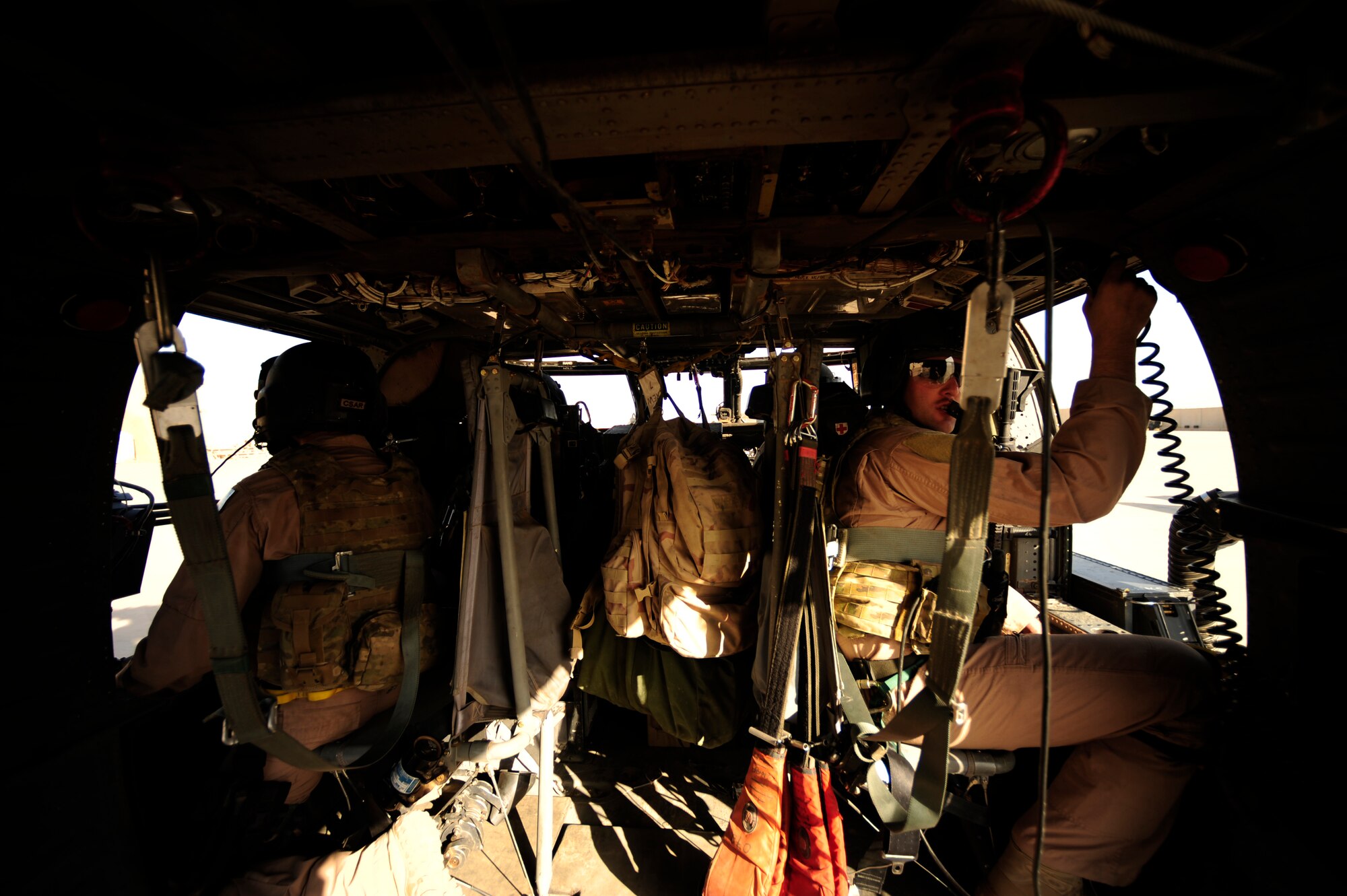 U.S. Air Force Staff Sgts. Andrew Pena, (left) and Aaron Walton assigned to the 64th Expeditionary Rescue Squadron look out their windows, scanning as aerial gunners during a flying mission at Joint Base Balad, Iraq, July 12, 2010. (U.S. Air Force photo by Staff Sgt. Andy M. Kin / Released)