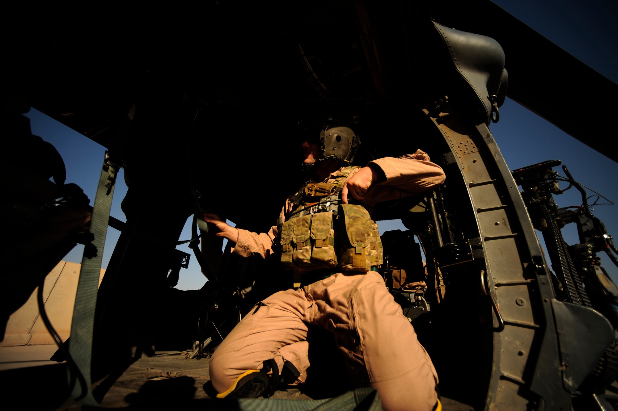 U.S. Air Force Staff Sgt. Aaron Walton, an HH-60G PaveHawk flight engineer assigned to the 64th Expeditionary Rescue Squadron, locks his gunner?s belt in place before a flying mission at Joint Base Balad, Iraq, July 12, 2010. (U.S. Air Force photo by Staff Sgt. Andy M. Kin / Released)