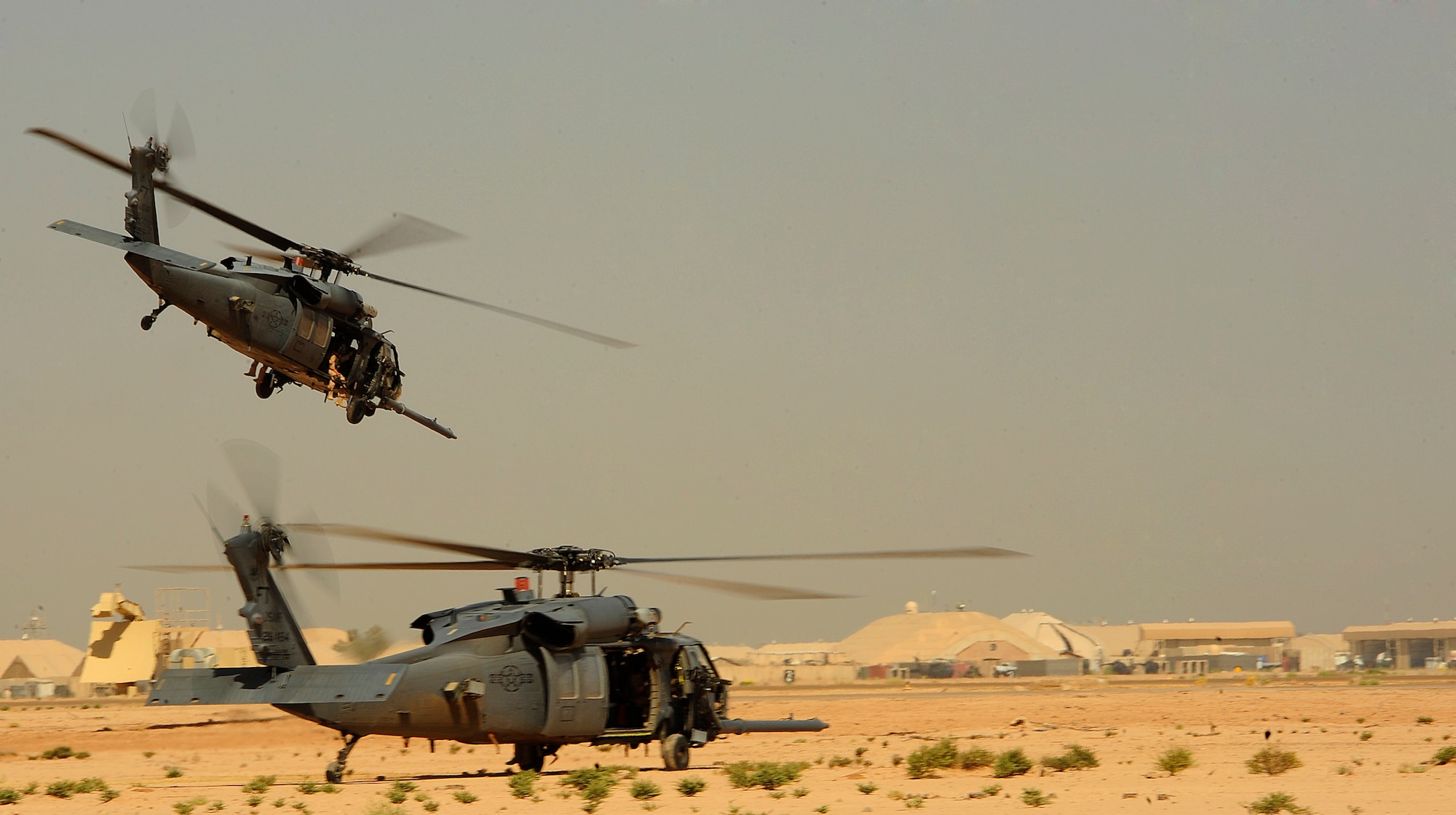 Two U.S. Air Force HH-60G PaveHawk helicopters flown by the 64th Expeditionary Rescue Squadron perform two-ship landing and takeoff maneuvers out of Joint Base Balad, Iraq, July 12, 2010. (U.S. Air Force photo by Staff Sgt. Andy M. Kin / Released)