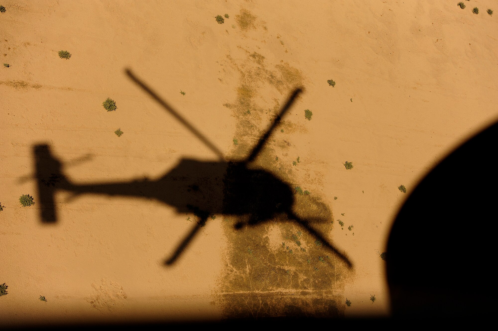 U.S. Air Force HH-60G PaveHawk helicopter assigned to the 64th Expeditionary Rescue Squadron is silhouetted on the bright desert sands during a flying mission at Joint Base Balad, Iraq, July 12, 2010. (U.S. Air Force photo by Staff Sgt. Andy M. Kin / Released)