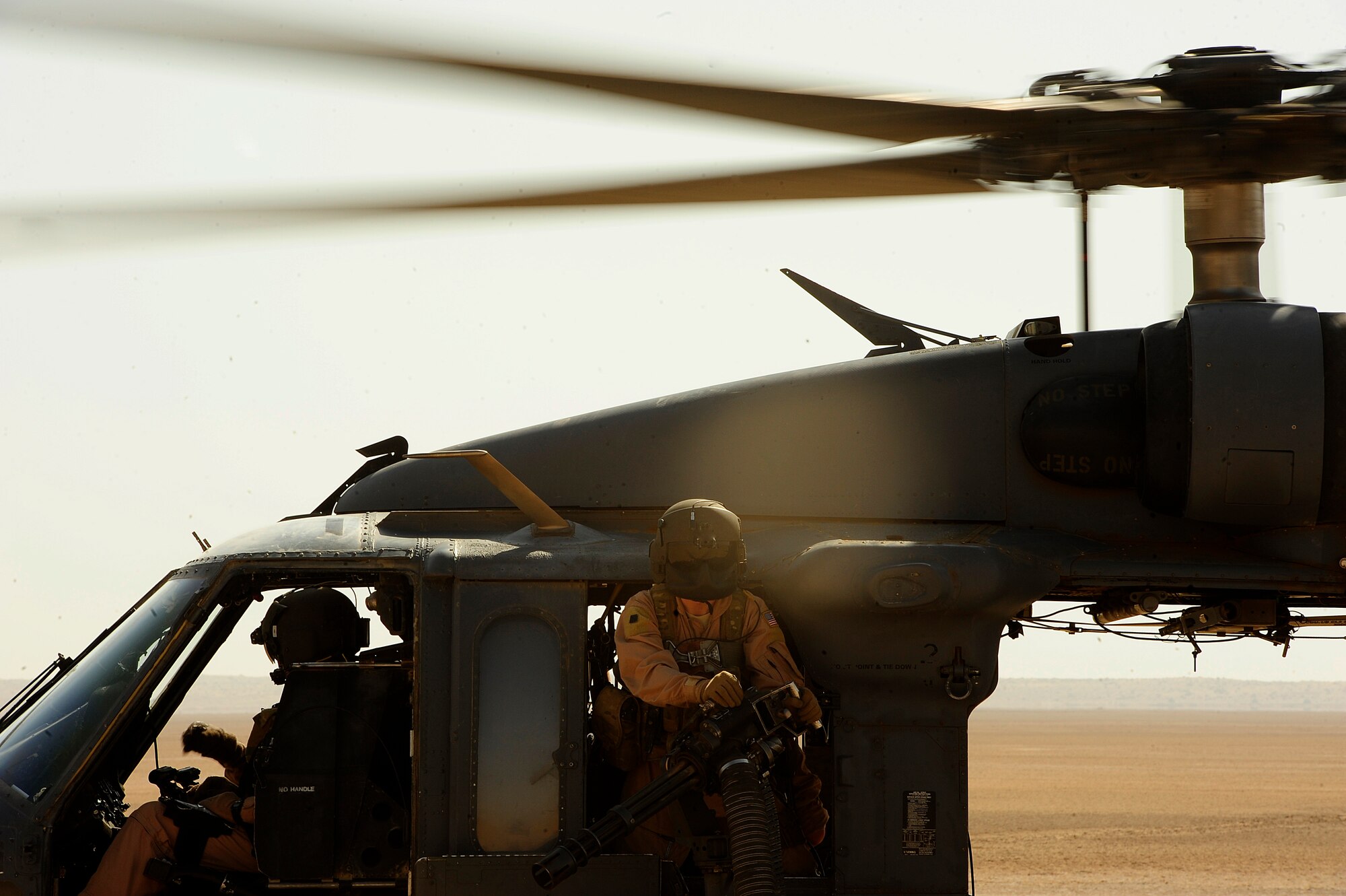 U.S. Air Force Senior Airman Josiah Hartline, an HH-60G PaveHawk aerial gunner assigned to the 64th Expeditionary Rescue Squadron, looks through window during a takeoff from landing zone at Joint Base Balad, Iraq, July 12, 2010. (U.S. Air Force photo by Staff Sgt. Andy M. Kin / Released)