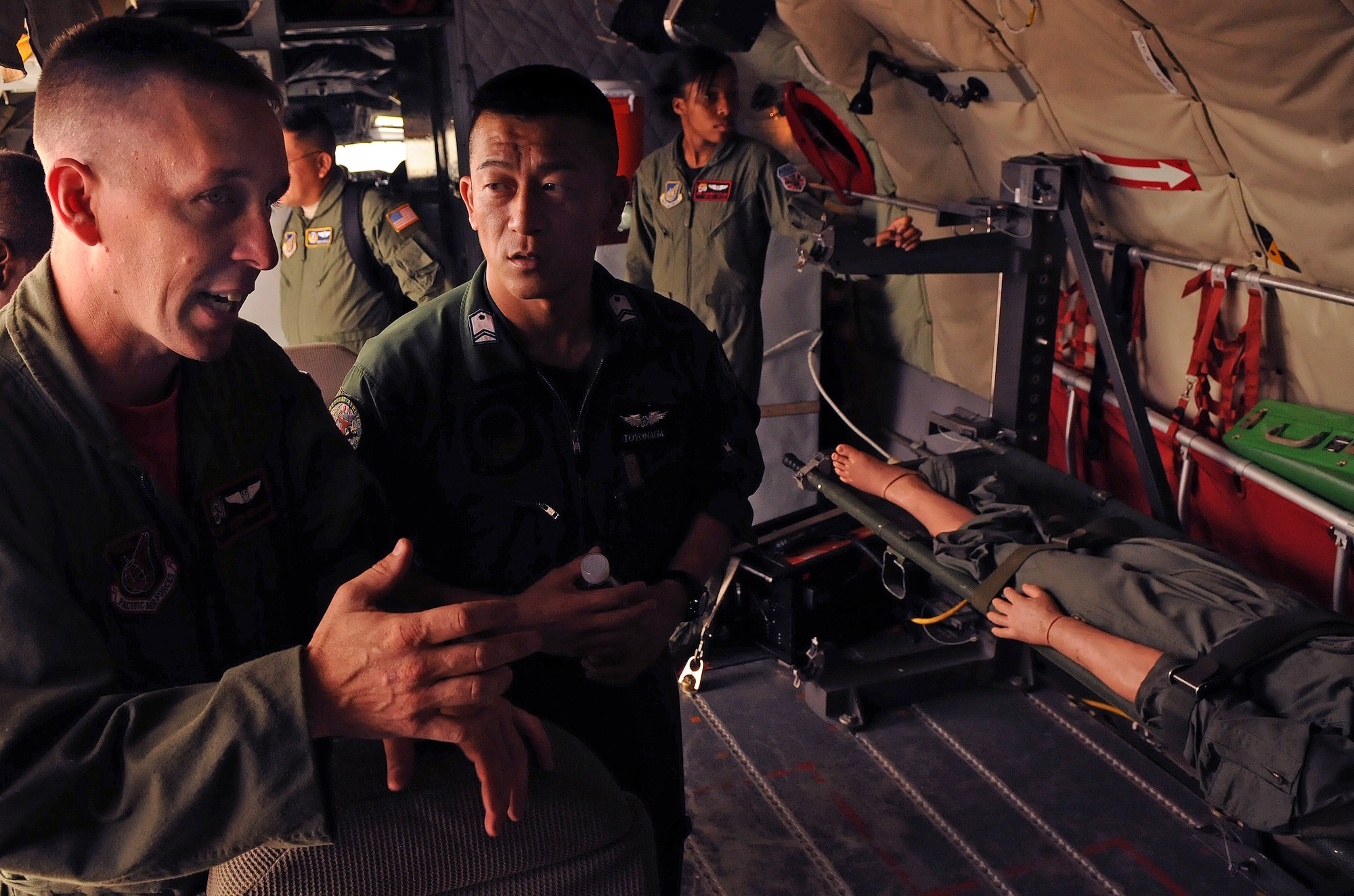 Tech. Sgt. Jason Wallace, 909th Air Refueling Squadron boom operator, shares his past experiences as a C-130 loadmaster with his Japan Air Self Defense Force counterpart during a bilateral aeromedical exchange July 23. Sergeant Wallace and other 909th ARS crewmembers talked about how they assist the 18th Aeromedical Evacuation Squadron accomplish their critical mission as the sole unit of their kind in the Western Pacific. (U.S. Air Force photo/Staff Sgt. Jason Lake)