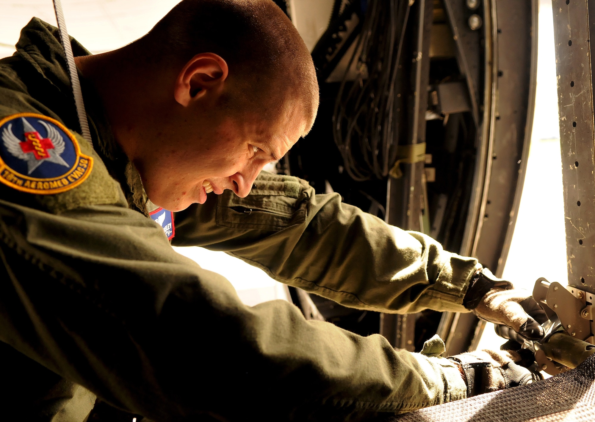 Senior Airman Nathan Easley, 18th Aeromedical Evacuation Squadron flight medic, secures a litter to the side hull of a C-130 in preparation for a bilateral aerovac exchange with the Japan Air Self Defense Force July 23. Airman Easley and other members of the 18th AES spoke to more than 30 JASDF airmen about their mission, equipment and individual responsibilities as the U.S. Air Force's only emergency aeromedical care providers in the Western Pacific. (U.S. Air Force photo/Staff Sgt. Jason Lake)