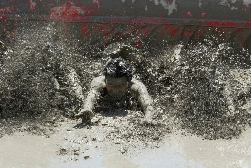 KUNSAN AIR BASE, Republic of Korea -- Visitors at the South Korea Boryeong Mud Festival make a splash sliding across the floor of a mud pit from one end to the other July 25. The festival, now in its 13th year, is one of the most popular tourist attractions in South Korea annually. (U.S. Air Force photo/Staff Sgt. Jonathan Pomeroy)