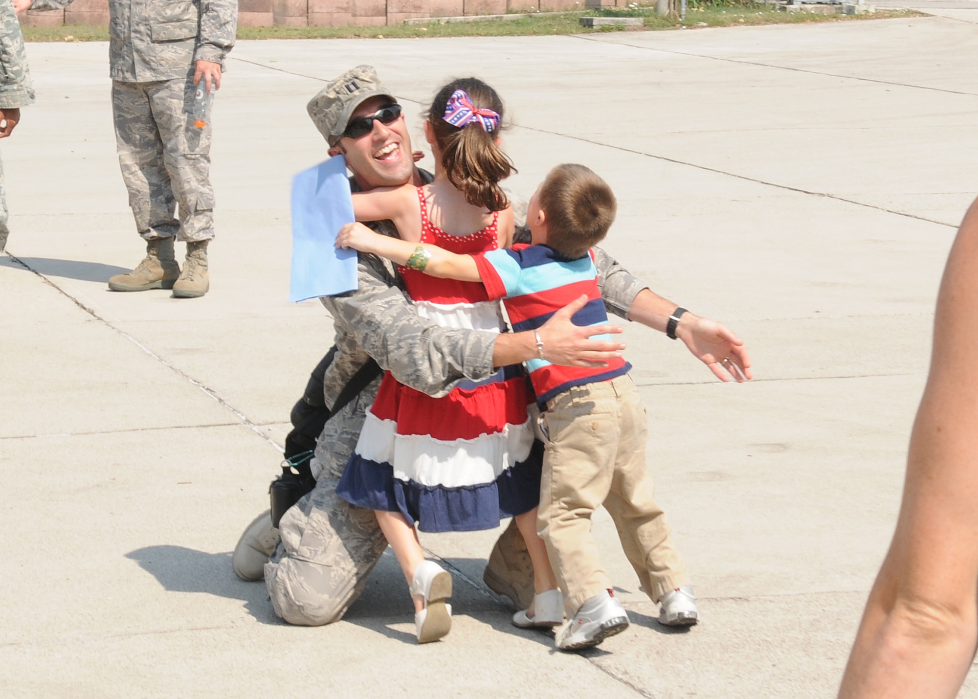 Capt. Kevin Fletcher, 603rd Air Control Squadron, embraces his children, Jessica and Timothy Fletcher, upon his return home to Aviano Air Base, Italy, July 23, 2010 from a six-month deployment to an unidisclosed location in Southwest Asia. More than 90 Airmen assigned to the 603rd ACS returned between July 12-23 from Kandahar, Afghanistan, and another undisclosed location downrange where they were conducting battle management of radio, radar and link support of Combined Forces Air Component commander objectives and supporting ground commander objectives by vectoring aircraft to troops in contact. (U.S. Air Force photo by Senior Airman Tabitha Lee/Released) 