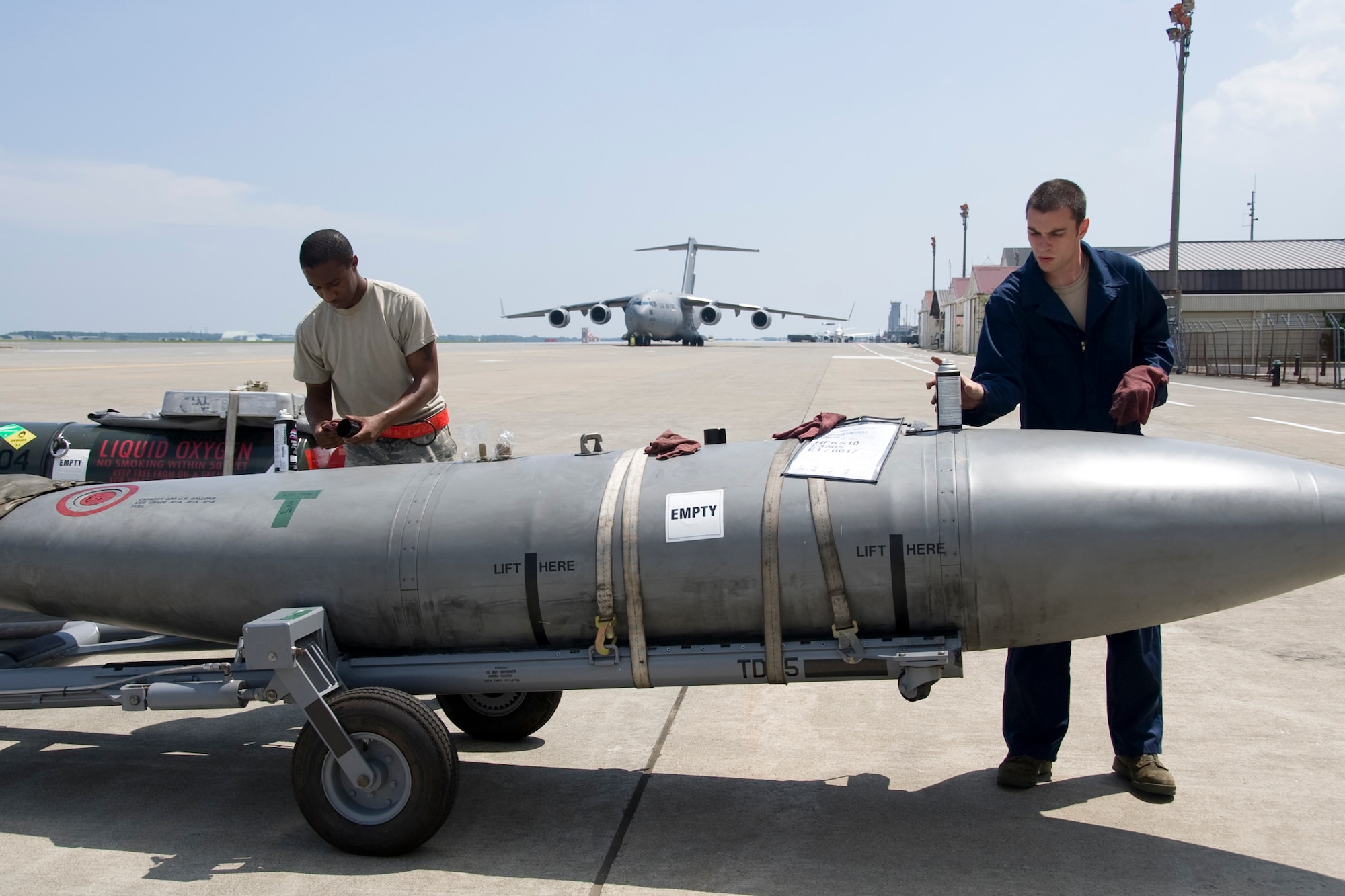 MISAWA AIR BASE, Japan -- Airman 1st Class Dorion Nelson, left, and Senior Airman Chase Rockcole, 35th Logistics Readiness Squadron cargo deployment function augmentees, clean a fuel tank July 21 outside of Hangar 949. The Airmen cleaned the tank before shipping to prevent the possibility of contamination from dirt and bacteria of one country to enter another. (U.S. Air Force photo/Senior Airman Jamal D. Sutter)