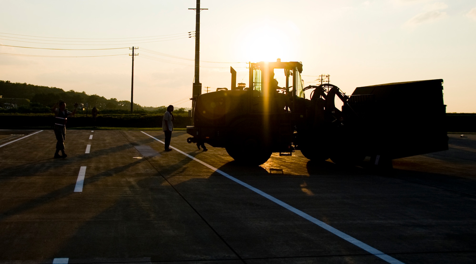 MISAWA AIR BASE, Japan -- Members of the 35th Logistics Readiness Squadron cargo deployment function transport equipment July 21 outside of Hangar 949. The team often beat sunrise and witnessed sunset to make sure necessary equipment and cargo was ready for flight. (U.S. Air Force photo/Senior Airman Jamal D. Sutter)