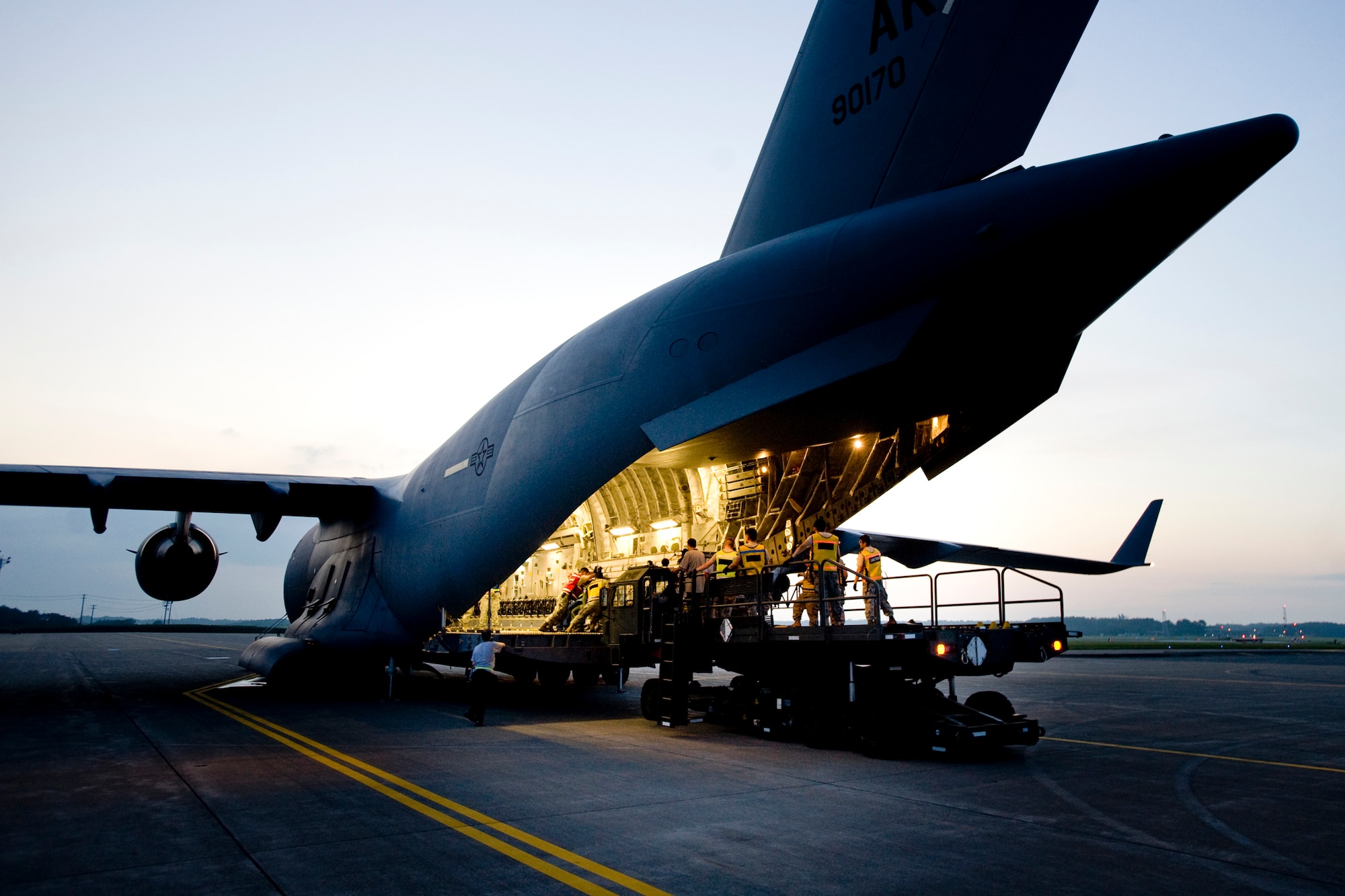 MISAWA AIR BASE, Japan -- Members of the 35th Logistics Readiness Squadron cargo deployment function load equipment to a C-17 July 21 on the flightline. The CDF is responsible for ensuring cargo pallets are properly built, labeled and ready to load on transport aircraft. (U.S. Air Force photo/Senior Airman Jamal D. Sutter)