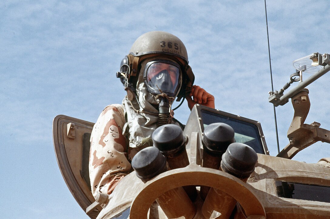 A U.S. Marine armored vehicle crewman wears a nuclear-biological-chemical protective mask while taking part in NBC training during Operation Desert Shield.