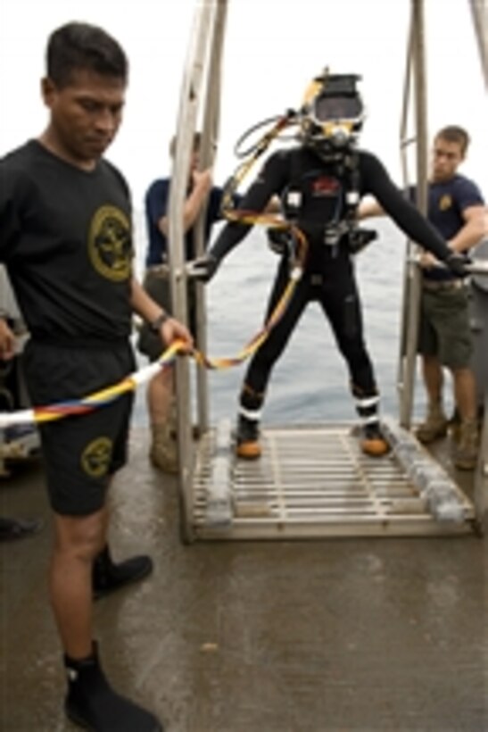U.S. Navy Petty Officer 2nd Class Matthew Wilson, assigned to Mobile Diving and Salvage Unit 2, waits to be lowered over the side of the USNS Grasp (T-ARS 51) on a staging platform during a salvage recovery exercise with Mexican navy divers in Veracruz, Mexico, on July 22, 2010.  Mobile Diving and Salvage Unit 2 is participating in Navy Diver-Southern Partnership Station, a multinational partnership engagement designed to increase interoperability and partner nation capacity through diving operations.  