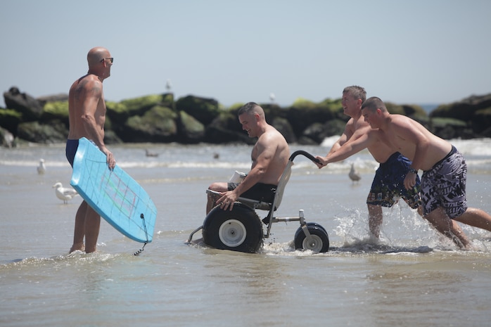 Adam Lyman is pushed out of the water by a team of Long Beach Waterfront Warriors volunteers, July 26, Long Beach, N.Y. Laman is a Marine veteran recovering at Walter Reed Medical Center. He is one of 34 service members the Long Beach Waterfront Warriors has brought to New York for a week-long respite for families going through the long process of recovering from war injuries.