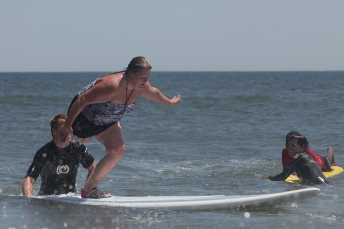 Tara Hutchinson surfs during the Long Beach Waterfront Warriors beach day, July 26, Long Beach, N.Y. She is one of 34 service members the Long Beach Waterfront Warriors has brought to New York for a week-long respite for families going through the long process of recovering from war injuries. Hutchinson has spent the last four years undergoing countless surgeries as she recovers from having her leg amputated. (Official Marine Corps photo by Sgt Randall A Clinton / RELEASED)