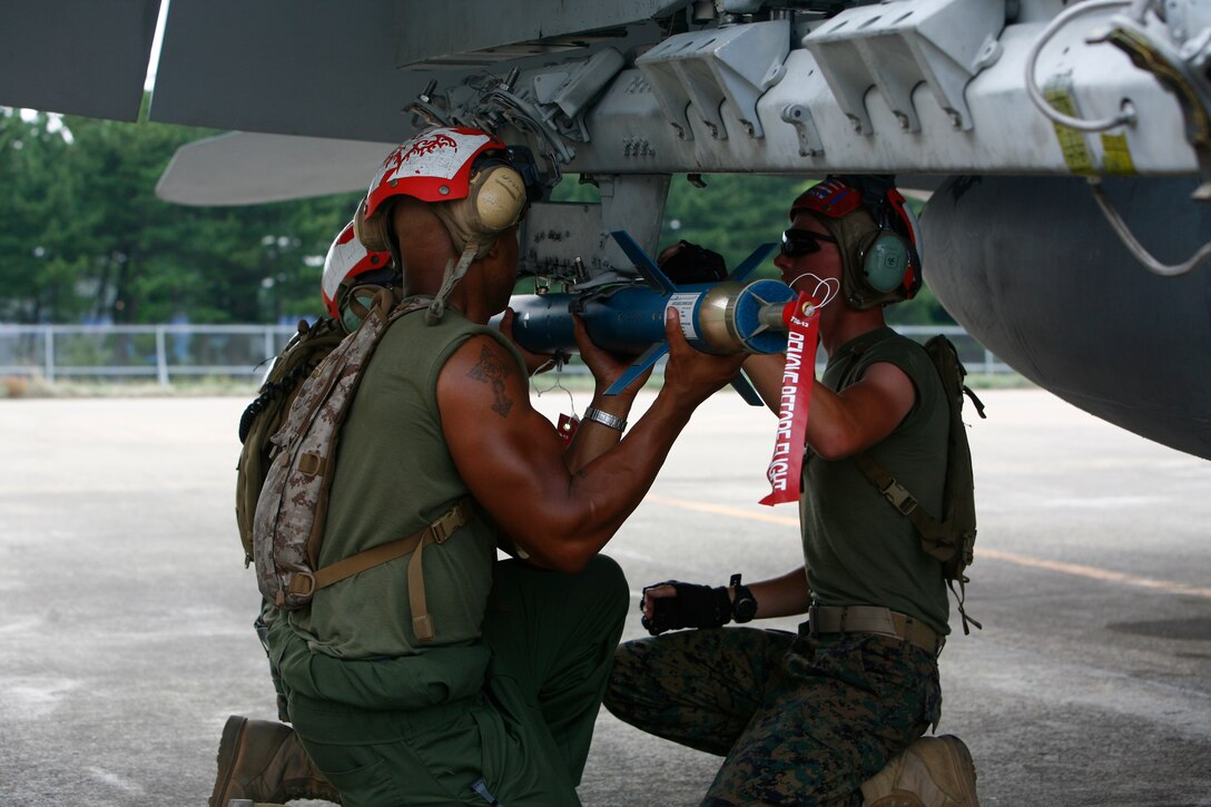 Marine All-Weather Fighter Attack Squadron 242 Ordnance Marines place a training missile onto an F/A-18 Hornet during exercise Invincible Spirit here July 27. During Invincible Spirit, VMFA(AW)-242, Marine Fighter Attack Squadron 542 and the Republic of Korea Air Force conducted numerous sorties to improve their interoperability and combat effectiveness.