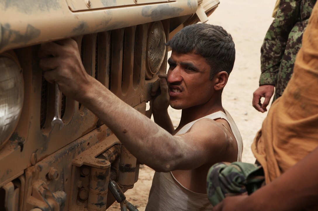 An Afghan mechanic with 5th Kandak, 1st Brigade, 215th Corps, partnered with Marines of Combat Logistics Battalion 5, Embedded Partnering Team, 1st Marine Logistics Group (Forward), performs maintenance on an M1152 Humvee Ambulance aboard Forward Operating Base Dwyer, Afghanistan, July 26. The CLB-5 EPT trains and mentors soldiers of the Afghan National Army to provide logistical capabilities in support of the International Security Assistance Force.