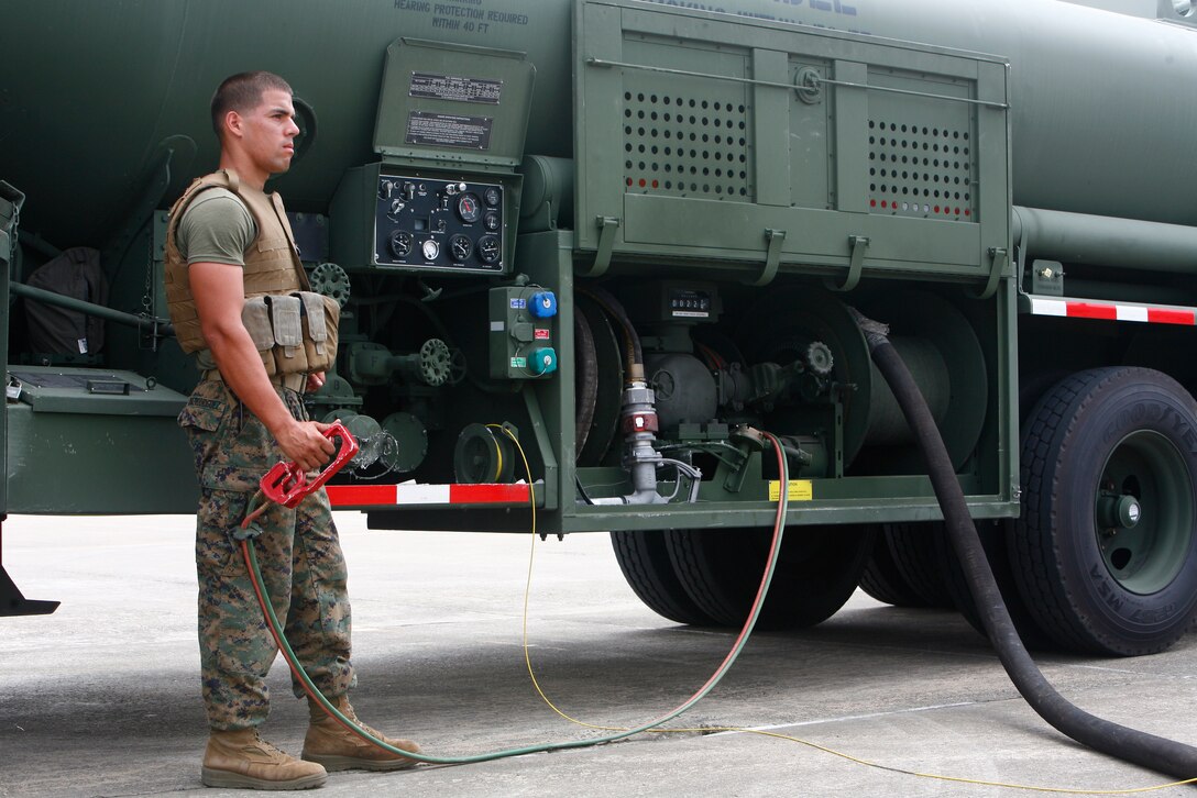 Lance Cpl. Nestor Diazrodriguez, a bulk fueler with Marine Wind Support Squadron 171, pumps jet fuel into an AV-8B Harrier during exercise Invincible Spirit here July 27. MWSS-171 provided more than 66,000 pounds of fuel for the exercise.