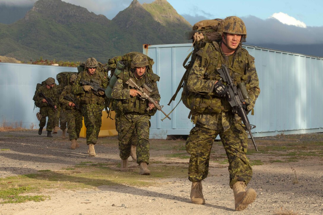 Canadian soldiers with Company G, 2nd Battalion, Royal Canadian Regiment, Canadian Army, move toward their next objective during a noncombatant evacuation operation at Marine Corps Training Area Bellows, Hawaii, July 26. The NEO, an emergency evacuation involving the use of military forces and capabilities in order to provide aid, assistance and movement to safety of American citizens overseas, was conducted as part of interoperability training between coalition forces during the multi-national Exercise Rim of the Pacific 2010.