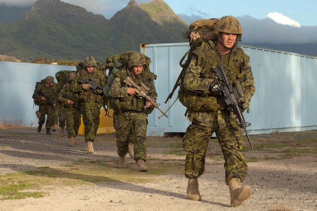 Canadian soldiers with Company G, 2nd Battalion, Royal Canadian Regiment, Canadian Army, move toward their next objective during a noncombatant evacuation operation at Marine Corps Training Area Bellows, Hawaii, July 26. The NEO, an emergency evacuation involving the use of military forces and capabilities in order to provide aid, assistance and movement to safety of American citizens overseas, was conducted as part of interoperability training between coalition forces during the multi-national Exercise Rim of the Pacific 2010.