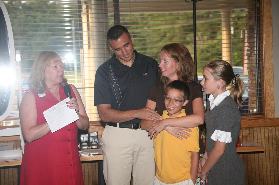 Gunnery Sgt. Jonathan A. Oakley, his wife, Tori, and children, Curtis and Destiny share the moment during the Havelock Service Family of the Quarter award ceremony at the Carolina Grill July 27.  The Oakley family received the award for their hard work and dedication to the local community. Oakley is the adjutant for the Center for Naval Aviation Technical Training Marine Unit.