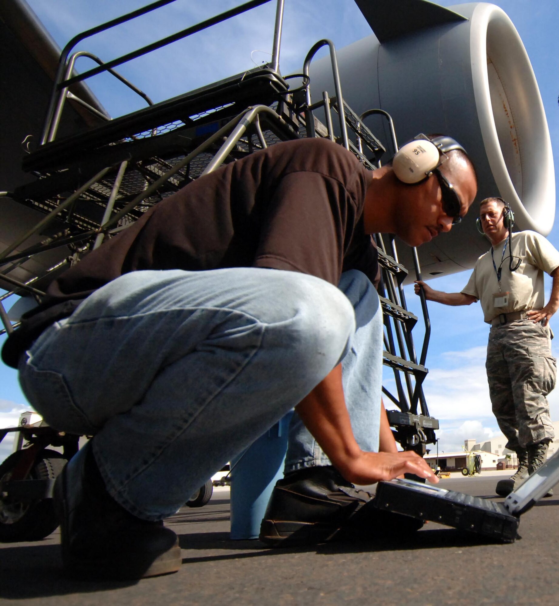 From left: Staff Sgt. El Rey Santiago, 154th Aircraft Maintenance Squadron hydraulics craftsman, and Tech. Sgt. Jason Liosi, 15th Aircraft Maintenance Squadron hydraulics craftsman perform maintenance on the hydraulics system of a C-17 engine July 23. The sortie this aircraft flew included a simulated cargo drop, in-flight refueling, and participation in a simulated fire fight as part of a Rim of the Pacific exercise. (U.S. Air Force photo by Staff Sgt. Nathan Allen)