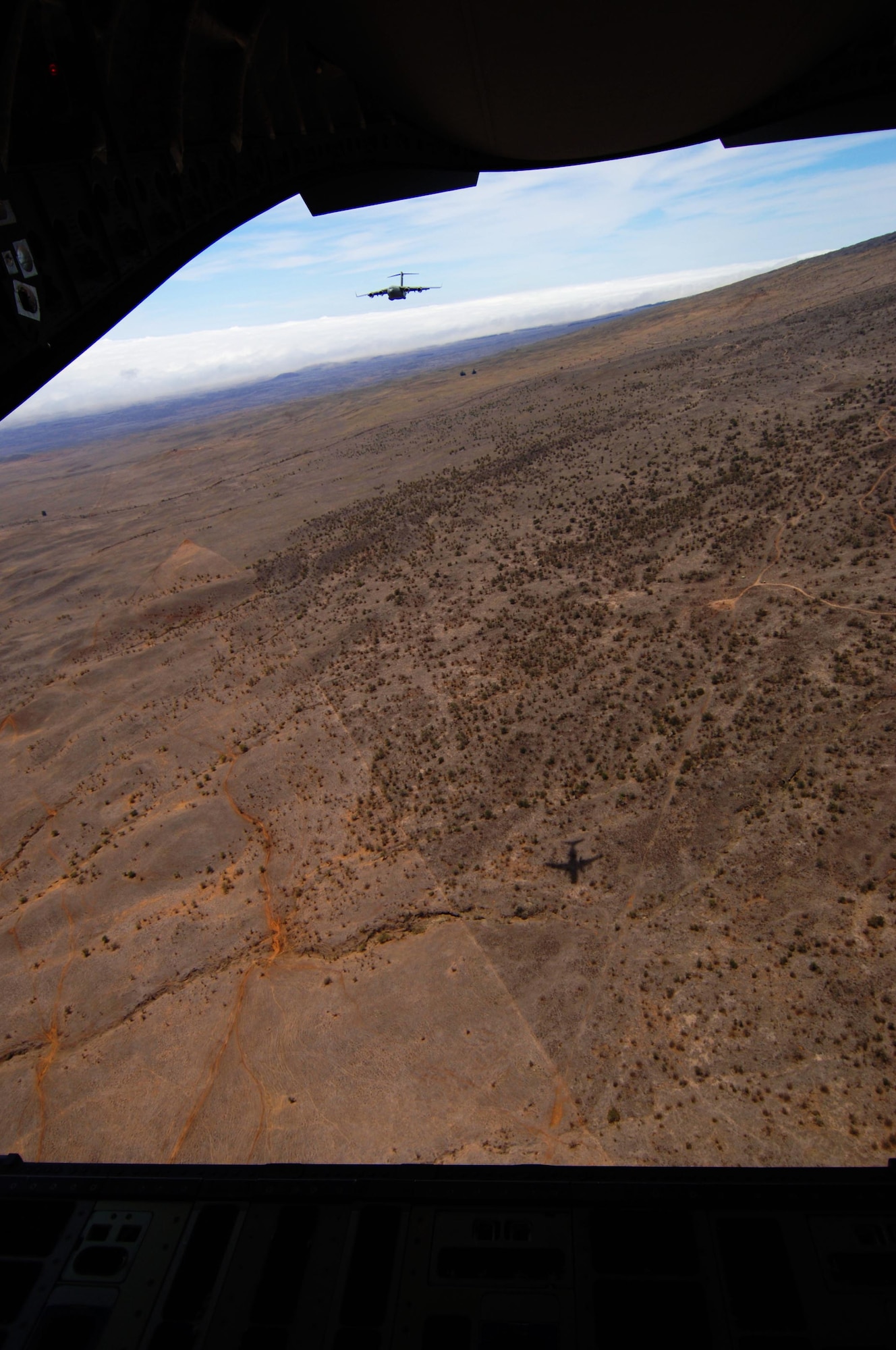 A C-17 flies as part of a two-ship formation over the island of Hawai'i in preparation for low-altitude flying maneuvers July 23. The sortie the lead aircraft flew included a simulated cargo drop, in-flight refueling, and participation in a simulated fire fight as part of a Rim of the Pacific exercise. (U.S. Air Force photo by Staff Sgt. Nathan Allen)
