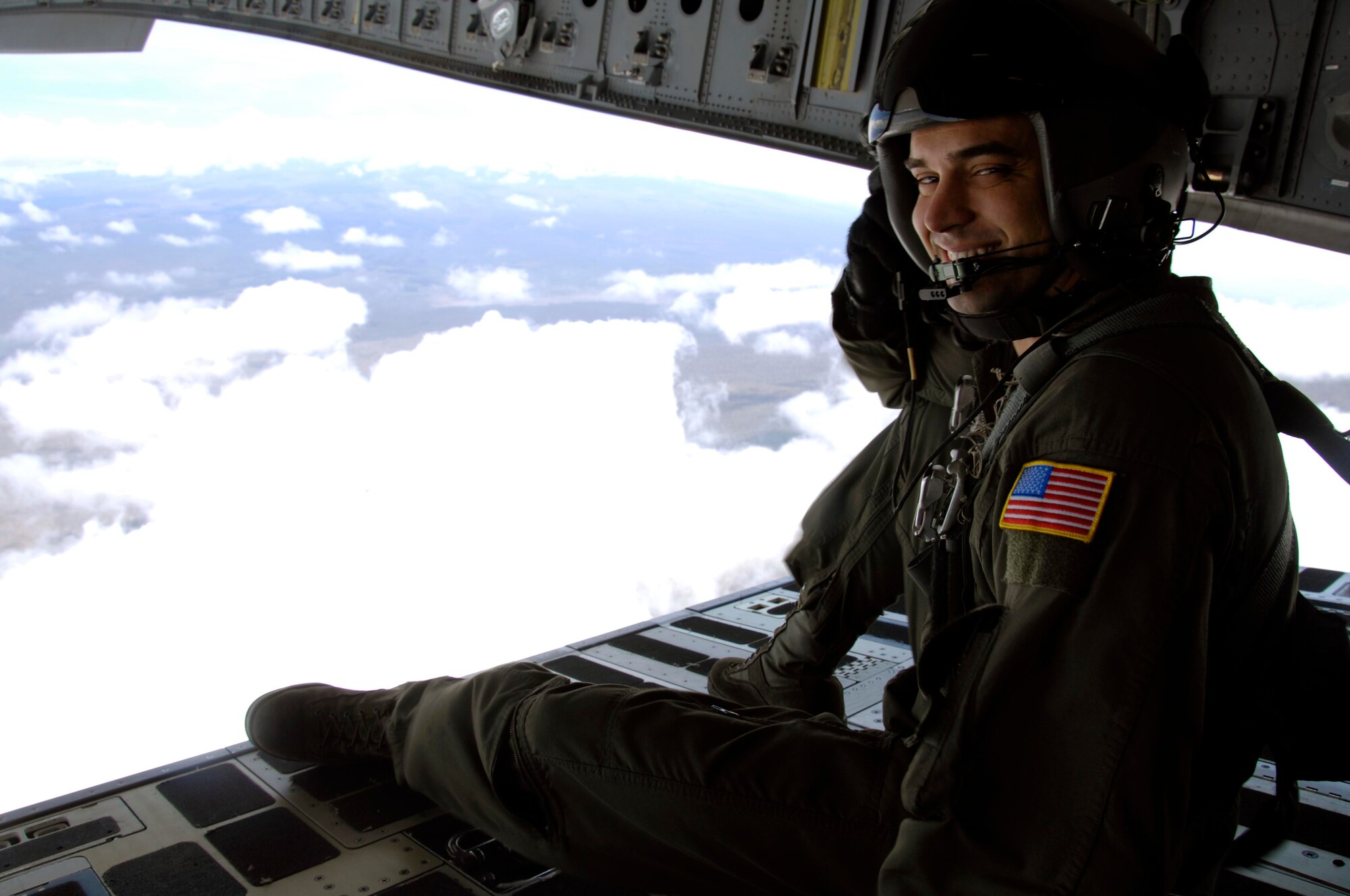 Staff Sgt. Keith Roscoe, 535th Airlift Squadron loadmaster enjoys the view from the back of a C-17 as it flies over the island of Hawaii July 23. The sortie this aircraft flew included a simulated cargo drop, in-flight refueling, and participation in a simulated fire fight as part of a Rim of the Pacific exercise. (U.S. Air Force photo by Staff Sgt. Nathan Allen)