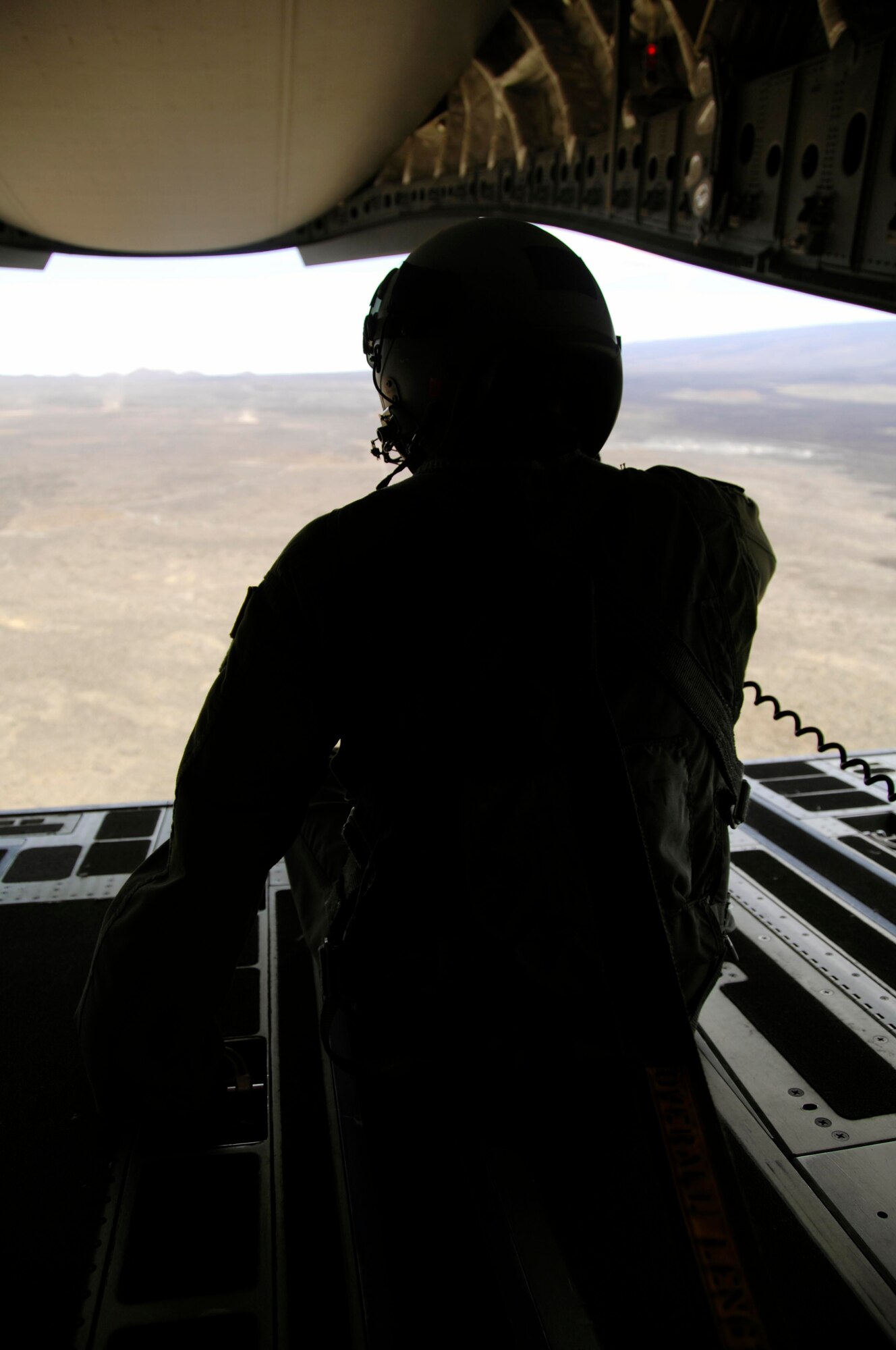 Staff Sgt. Keith Roscoe, 535th Airlift Squadron loadmaster enjoys the view from the back of a C-17 as it flies over the island of Hawaii July 23. The sortie this aircraft flew included a simulated cargo drop, in-flight refueling, and participation in a simulated fire fight as part of a Rim of the Pacific exercise. (U.S. Air Force photo by Staff Sgt. Nathan Allen)