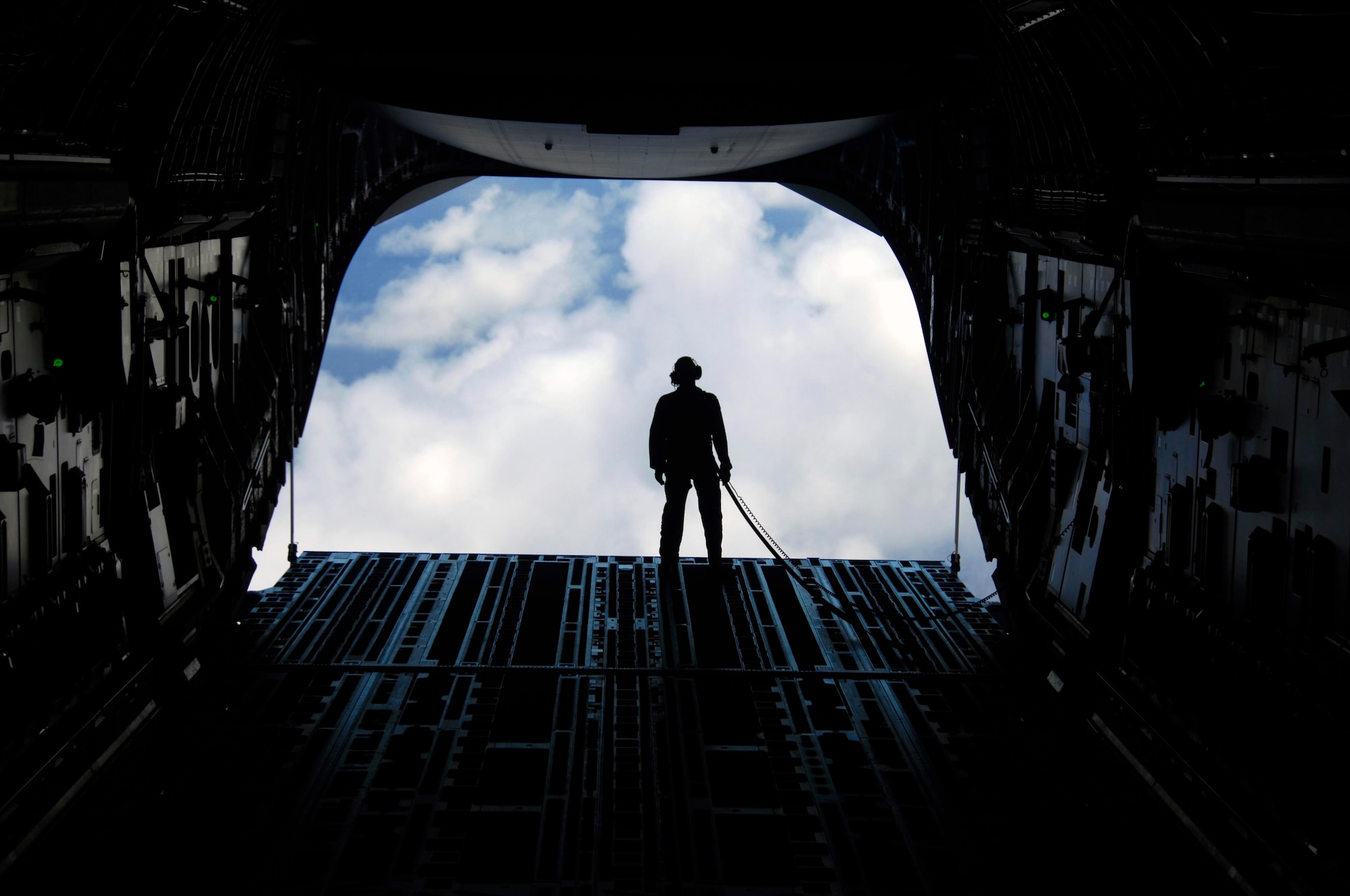 Staff Sgt. Keith Roscoe, 535th Airlift Squadron loadmaster enjoys the view from the back of a C-17 as it flies over the island of Hawaii July 23. The sortie this aircraft flew included a simulated cargo drop, in-flight refueling, and participation in a simulated fire fight as part of a Rim of the Pacific exercise. (U.S. Air Force photo by Staff Sgt. Nathan Allen)