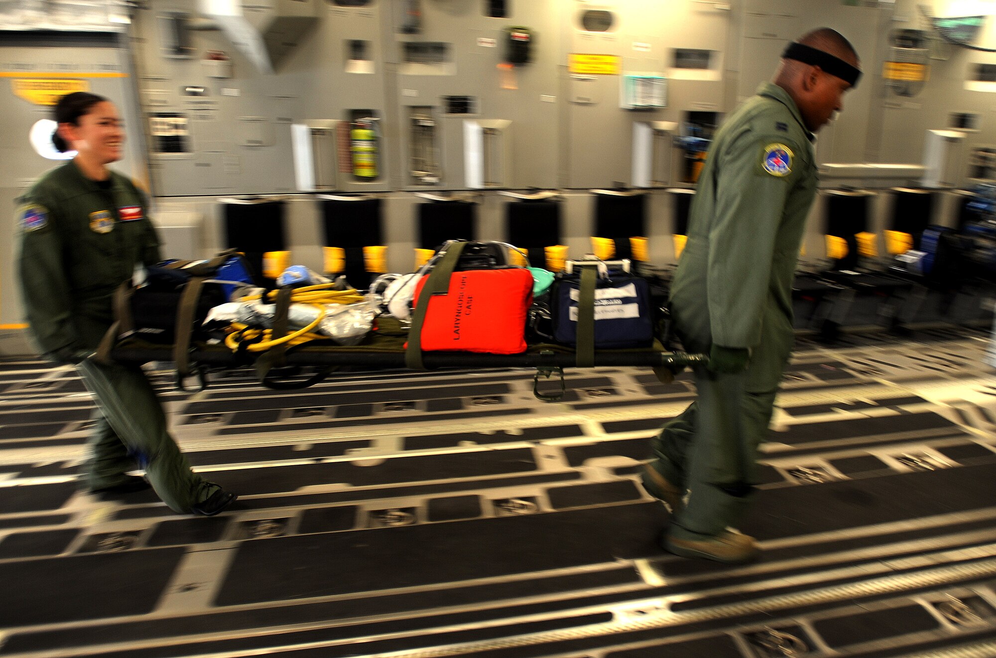 Staff Sgt Brittany Zavala, left, an aeromedical evacuation technician and Captain Roderick Reid, a flight nurse, both from the 775th Expeditionary Aerial Evacuation Flight Travis Air Force Base, Calif., carry medical supplies on board a C-17 Globemaster aircraft at Travis AFB in preparation for the weekly Integrated Continental United States Medical Operations Plan mission or ICMOP mission as it's known by it's acronym. The mission picks up war wounded and other patients at Andrews Air Force Base, Md., and returns them to their homes throughout the United States.   (U.S. Air Force photo by Master Sgt. Rick Sforza)