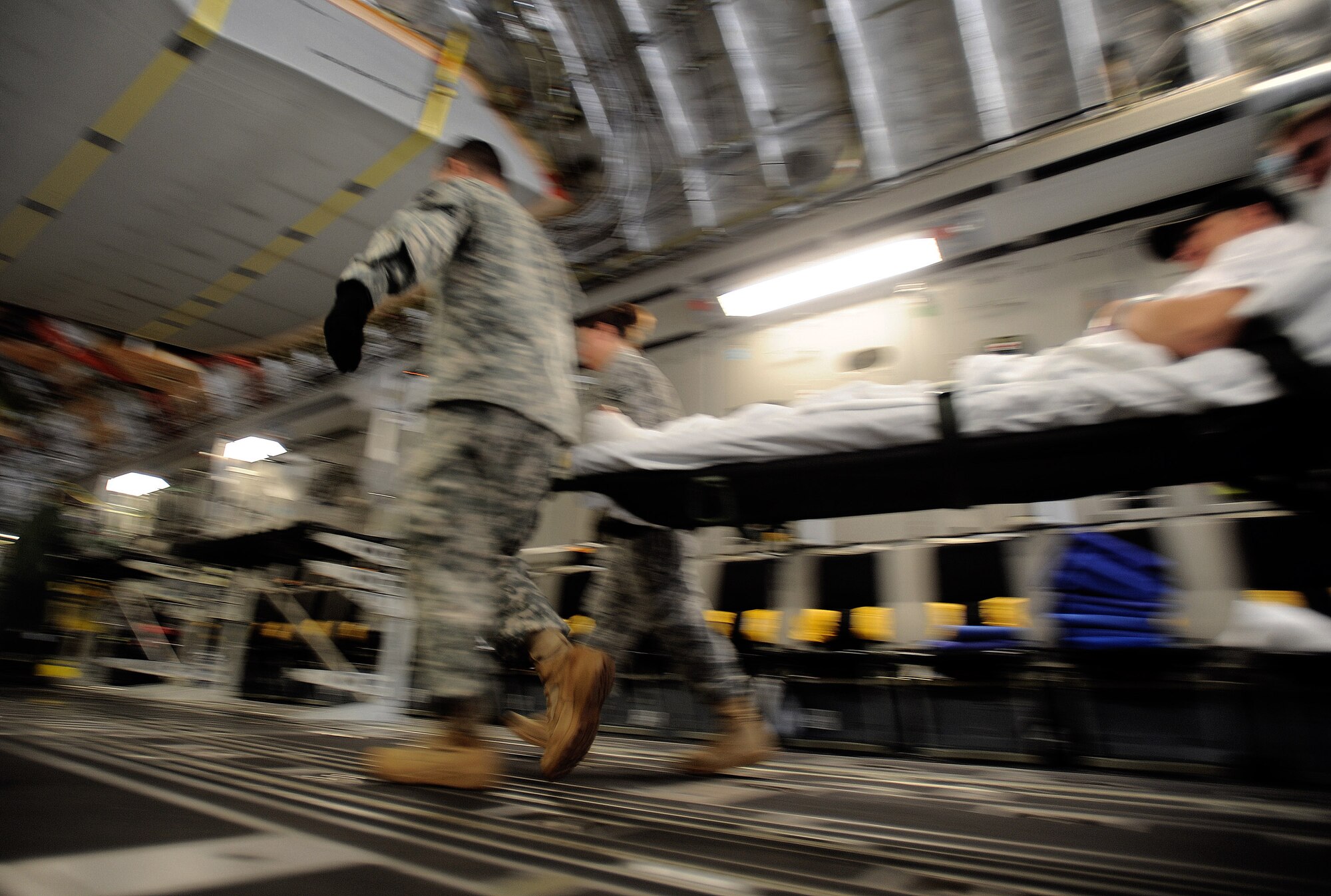 An aeromedical evacuation team loads a patient on board a C-17 Globemaster aircraft at Andrews Air Force Base, Md., in preparation for the weekly Integrated Continental United States Medical Operations Plan mission or ICMOP mission as it's known by it's acronym. The mission picks up war wounded and other patients at Andrews AFB and returns them to their homes throughout the United States.  (U.S. Air Force photo by Master Sgt. Rick Sforza)