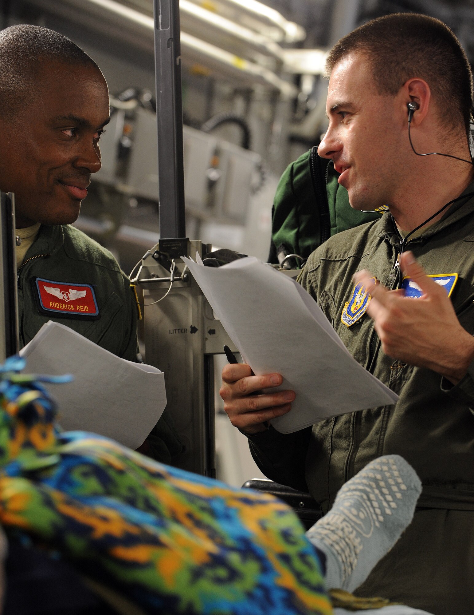 Captain Roderick Reid, left, a flight nurse, and Tech Sgt Nicholas Henchey, an aeromedical evacuation technician, both from the 775th Expeditionary Aeromedical Evacuation Flight Travis Air Force Base, Calif., discuss patient care on board a C-17 Globemaster aircraft during a flight from Andrews Air Force Base, Md., on the weekly Integrated Continental United States Medical Operations Plan mission or ICMOP mission as it's known by it's acronym. The mission picks up war wounded and other patients at Andrews AFB and returns them to their homes throughout the United States.   (U.S. Air Force photo by Master Sgt. Rick Sforza)