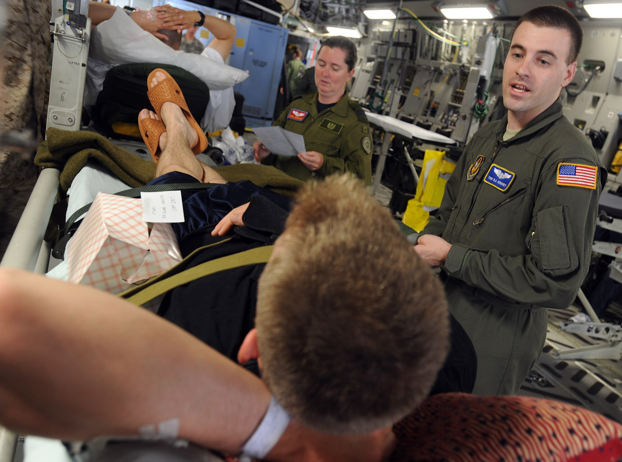 Tech. Sgt. Nicholas Henchey, an aeromedical evacuation technician from the 775th Expeditionary Aeromedical Evacuation Flight, Travis Air Force Base, Calif., talks to a patient on board a C-17 Globemaster aircraft on a flight from Andrews Air Force Base, Md., during the weekly ICMOP mission. (U.S. Air Force photo by Master Sgt. Rick Sforza)