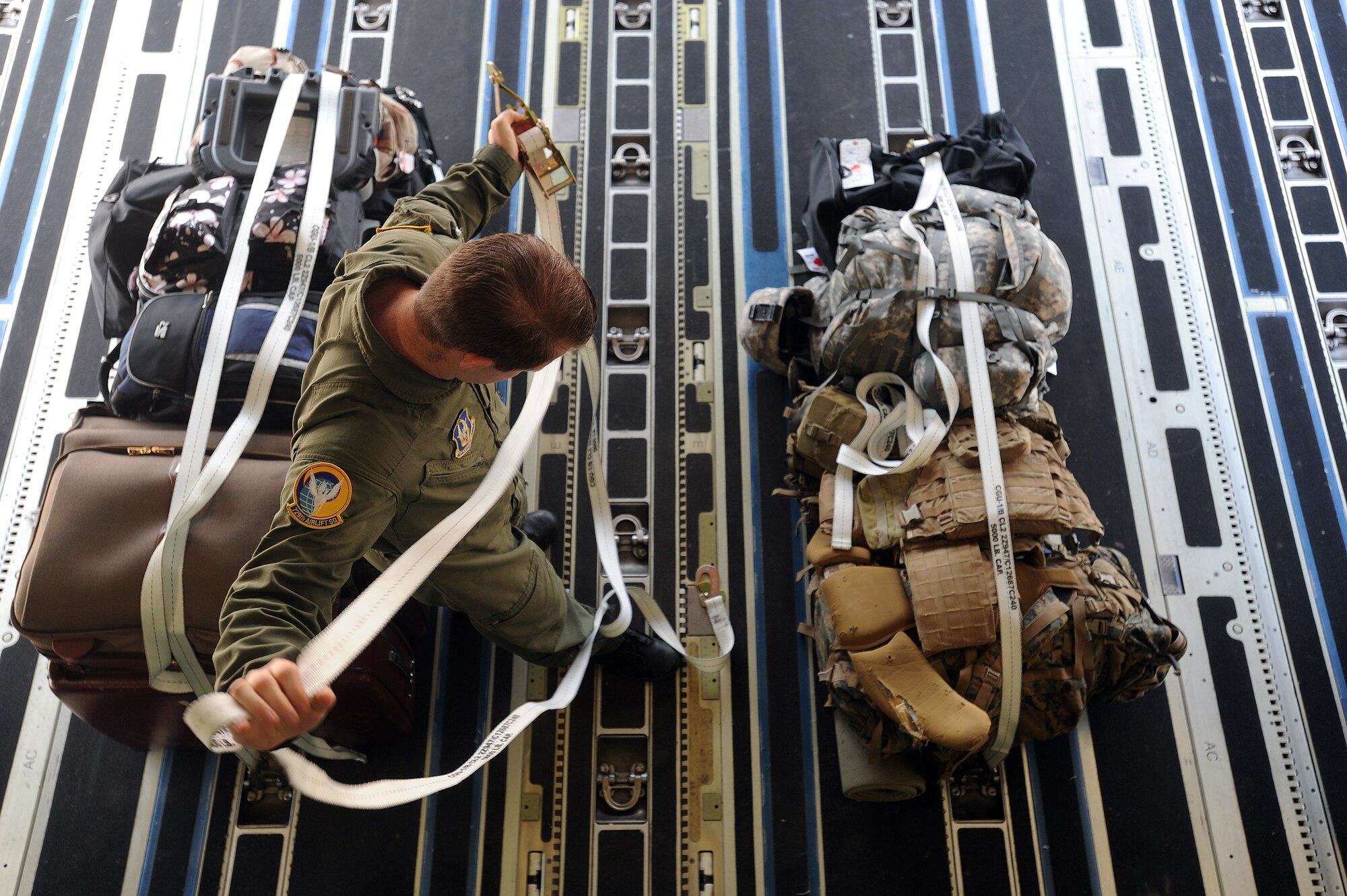 Tech. Sgt. Geoff Parrish, a loadmaster from the 729th Airlift Squadron at March, secures patient and passenger luggage aboard a C-17 at Scott Air Force Base, Ill., after dropping off patients during the weekly ICMOP mission. The mission picks up war wounded and other patients at Andrews Air Force Base, Md., and returns them to their homes throughout the United States. (U.S. Air Force photo by Master Sgt. Rick Sforza)