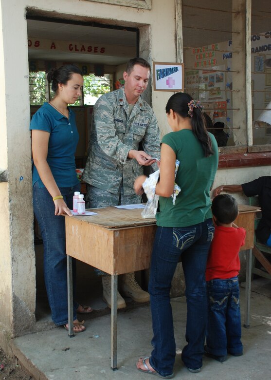 DUYURE, Honduras -- Air Force Maj. Brian Sydnor, a pharmacist in Joint Task Force-Bravo's Medical Element, provides medication to a Honduran mother and child during a Medical Civic Assistance Program here July 20. During the MEDCAP, a team of Honduran health care providers and JTF-Bravo personnel treated 435 Duyure residents in need of medical care. (U.S. Air Force photo by 1st Lt. Jen Richard)