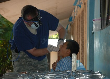 DUYURE, Honduras -- Air Force Lt. Col. Thomas Edmonson, a dentist in Joint Task Force-Bravo's Medical Element, provides dental care to a Honduran boy during a Medical Civic Assistance Program here July 20. During the MEDCAP, a team of Honduran health care providers and JTF-Bravo personnel treated 435 Duyure residents in need of medical care. (U.S. Air Force photo by 1st Lt. Jen Richard)