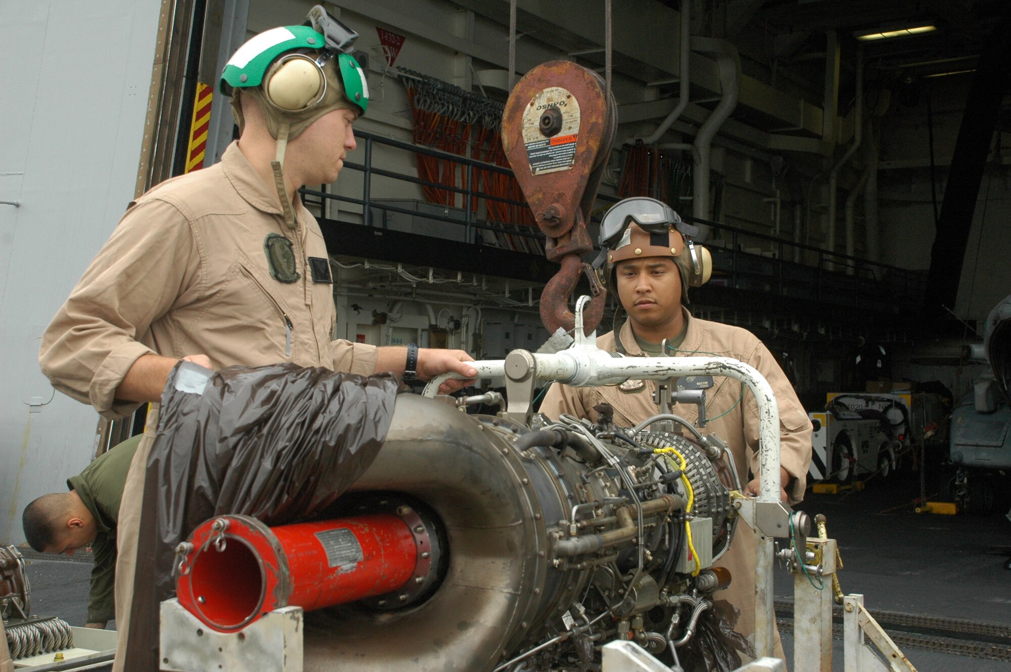 On board the USS New Orleans, Marine reservists, attached to Special Purpose Marine Air-Ground Task Force 24, work to replace two broken turbine engines that grounded two CH-46 Sea Knight helicopters. The helicopters are supporting aerial operations, transport and movements for multinational exercises Partnership of the Americas and Southern Exchange 2010, July 14. (USMC photo by Cpl. Brian Slaght)