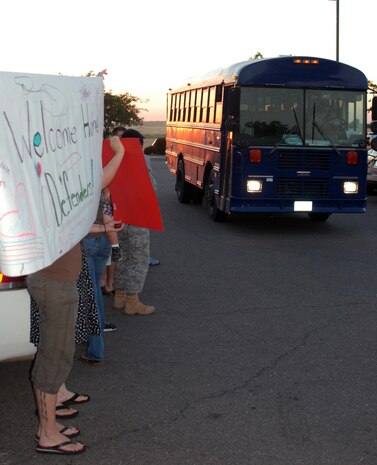 Family members display banners welcoming home members of the 9th Security Forces Squadron July 26 as they returned home from a six-month deployment to Bagram Airfield, Afghanistan. The 9th SFS members encountered heavy fire on multiple occasions and staged off several attacks while deployed. (Photo by Airman 1st Class Chuck Broadway)