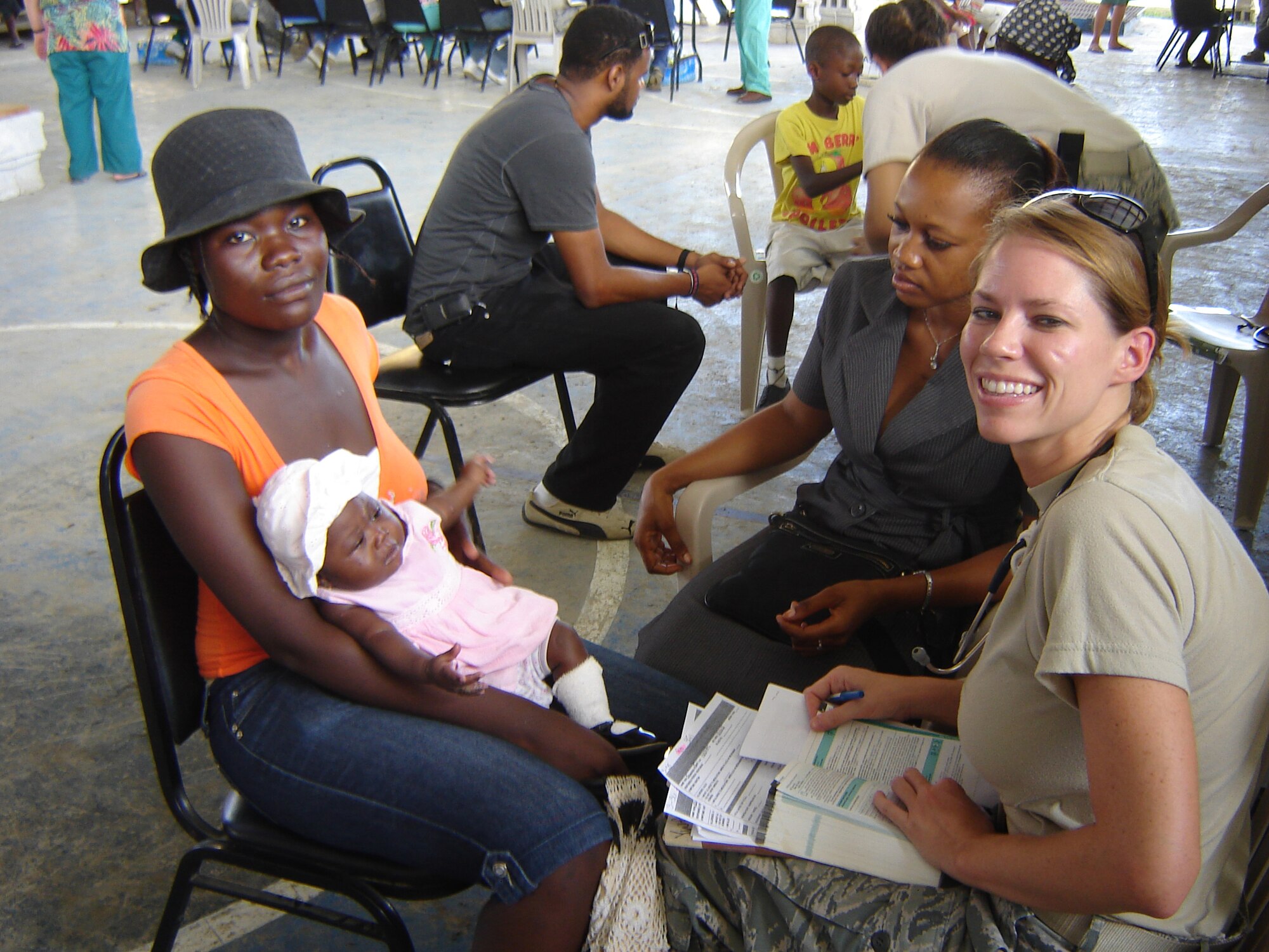 Capt. Erin Winkler, 20th MDG pediatrician goes over paperwork with patients.  The 20th Medical Group were the first team to arrive in Haiti to support the New Horizons Haiti mission The 20th MDG Airmen set up a medical outreach at Saint-Marc, Haiti, about 60 miles north of Port-au-Prince during the two and a half week deployment. (Courtesy photo)      
