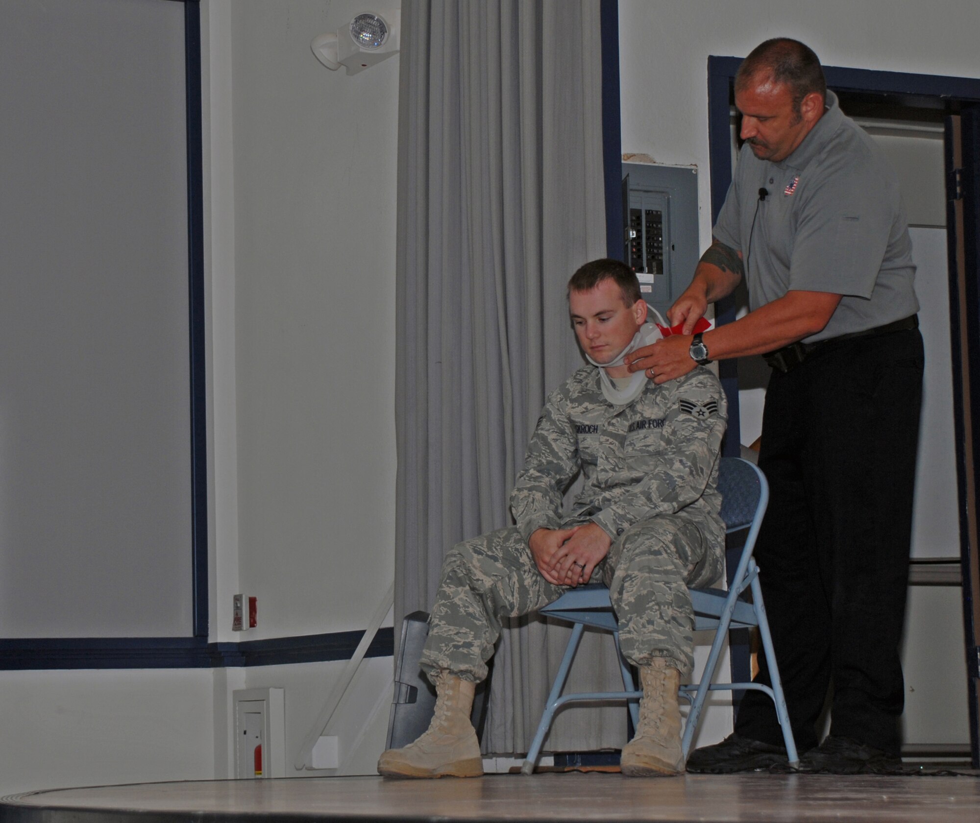 CREECH AFB, Nev. -- Pat Kelly places a neck brace on a volunteer during the Stay Alive From Education (SAFE) Street Smart briefing. (U.S. Air Force photo)