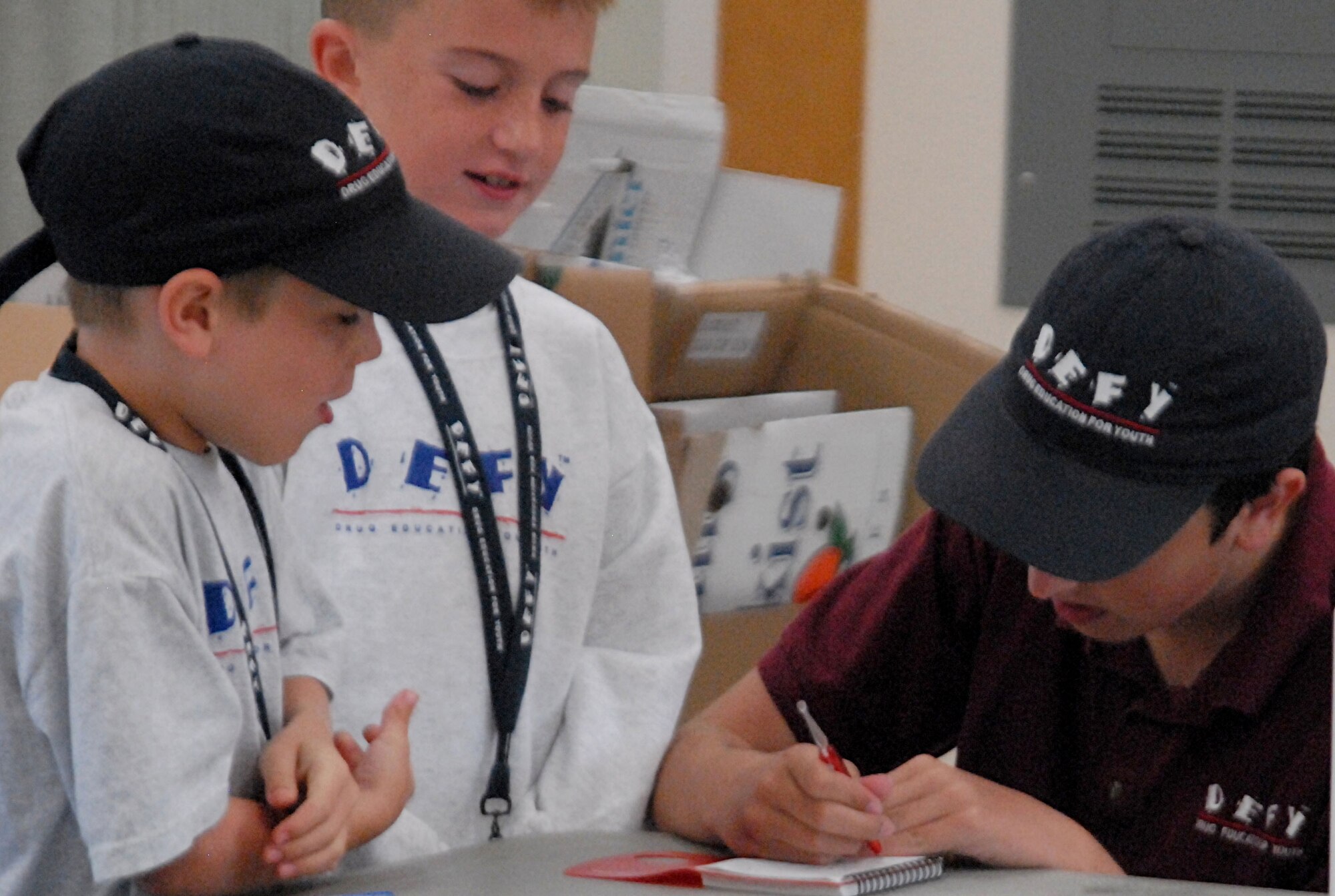 Andrew Mutka, Brandon Godin and Chris Mutka enjoy a game of hangman during some down time at DEFY camp July 27. DEFY camp attendees spent eight days from 7 a.m.-4 p.m. here learning about drug resistance. (U.S. Air Force photo/Connie Hempel)